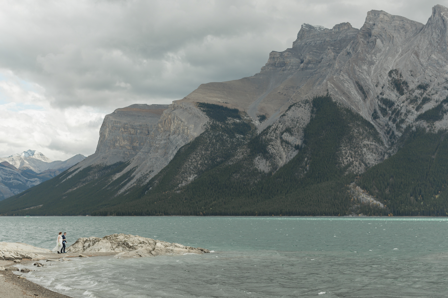 A LGBTQIA+ couple after their wedding exploring Lake Minnewanka 