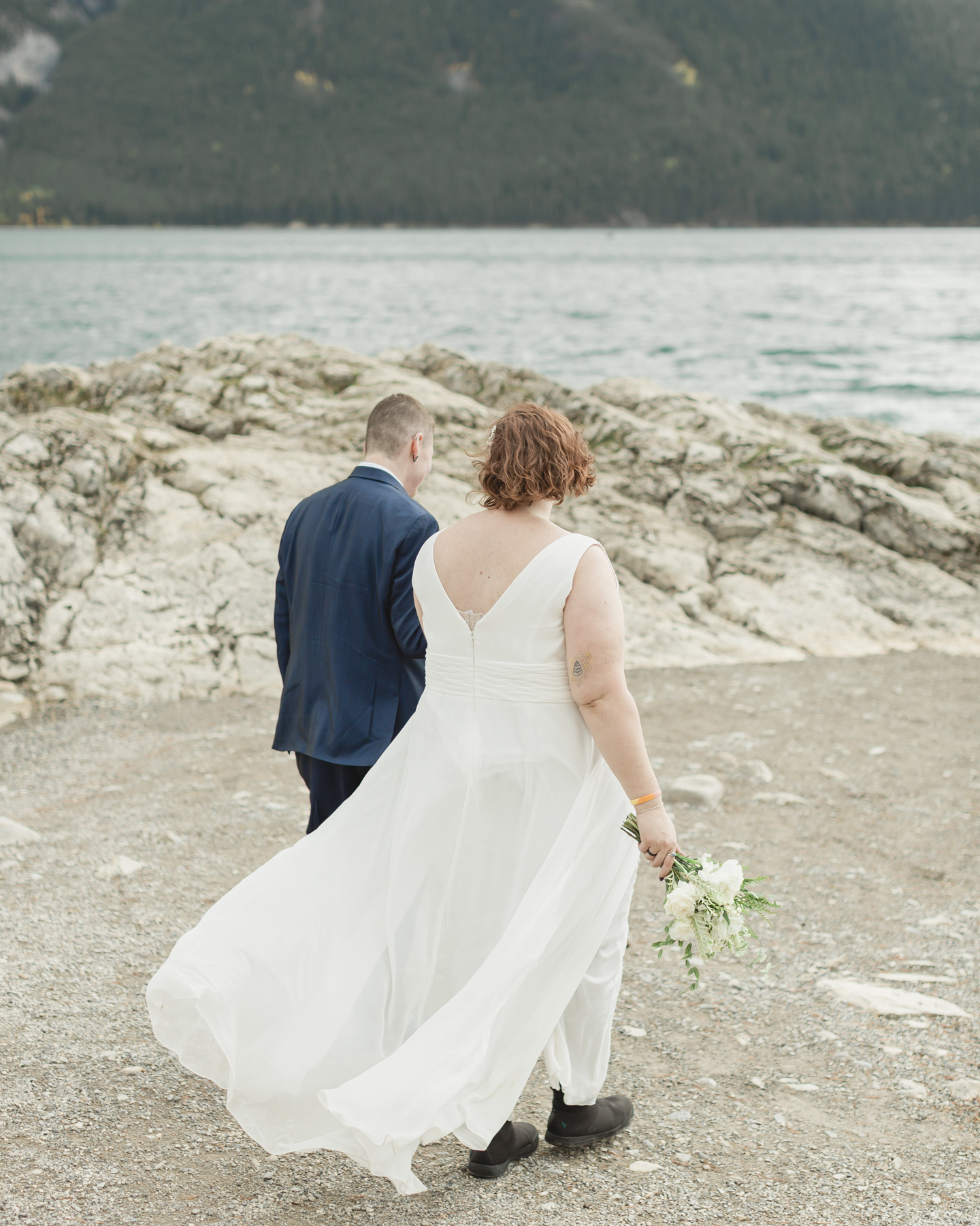 A LGBTQIA+ couple after their wedding exploring Lake Minnewanka 