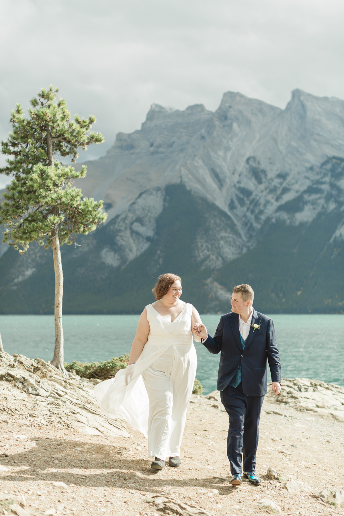 A LGBTQIA+ couple after their wedding exploring Lake Minnewanka 