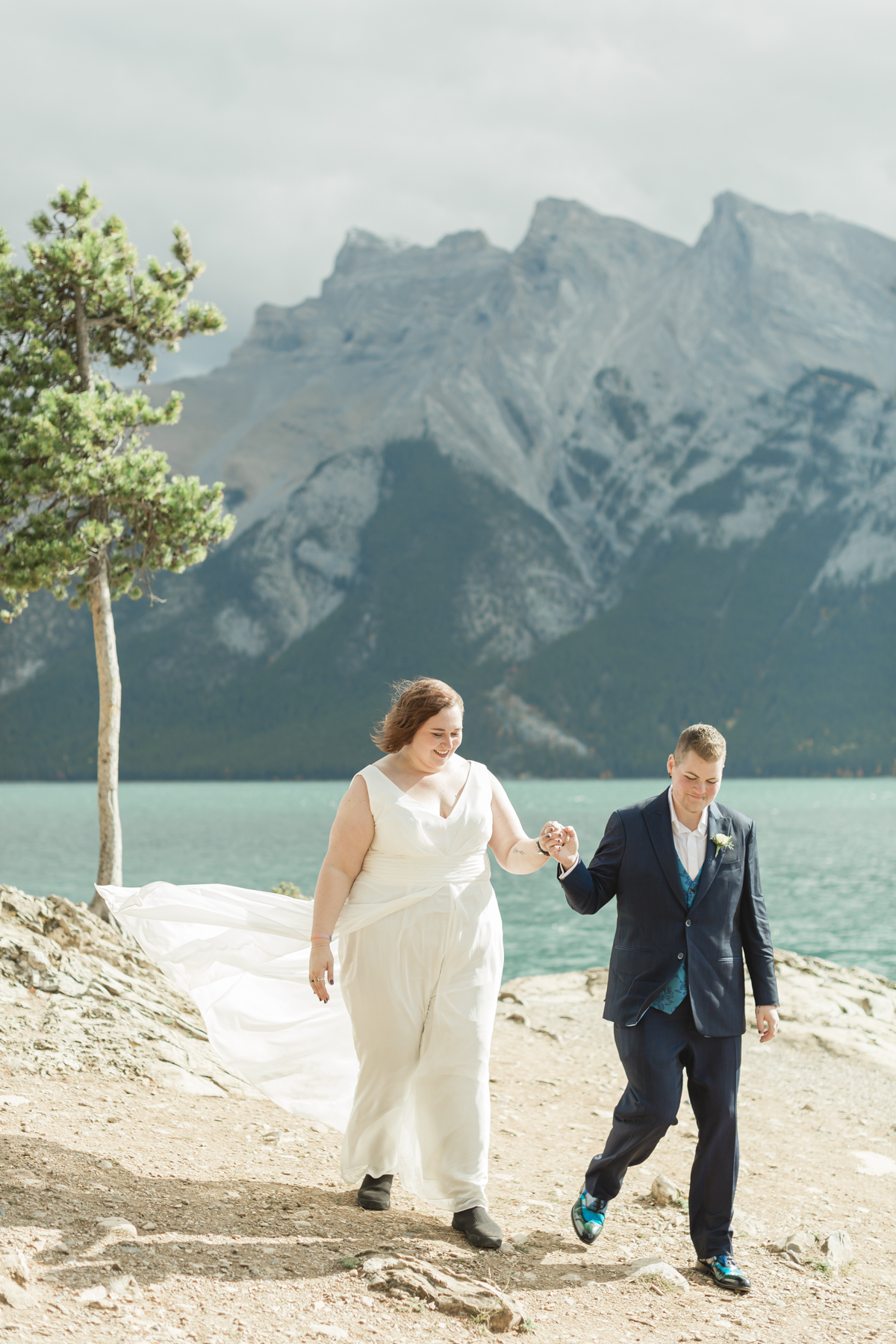 A LGBTQIA+ couple after their wedding exploring Lake Minnewanka 