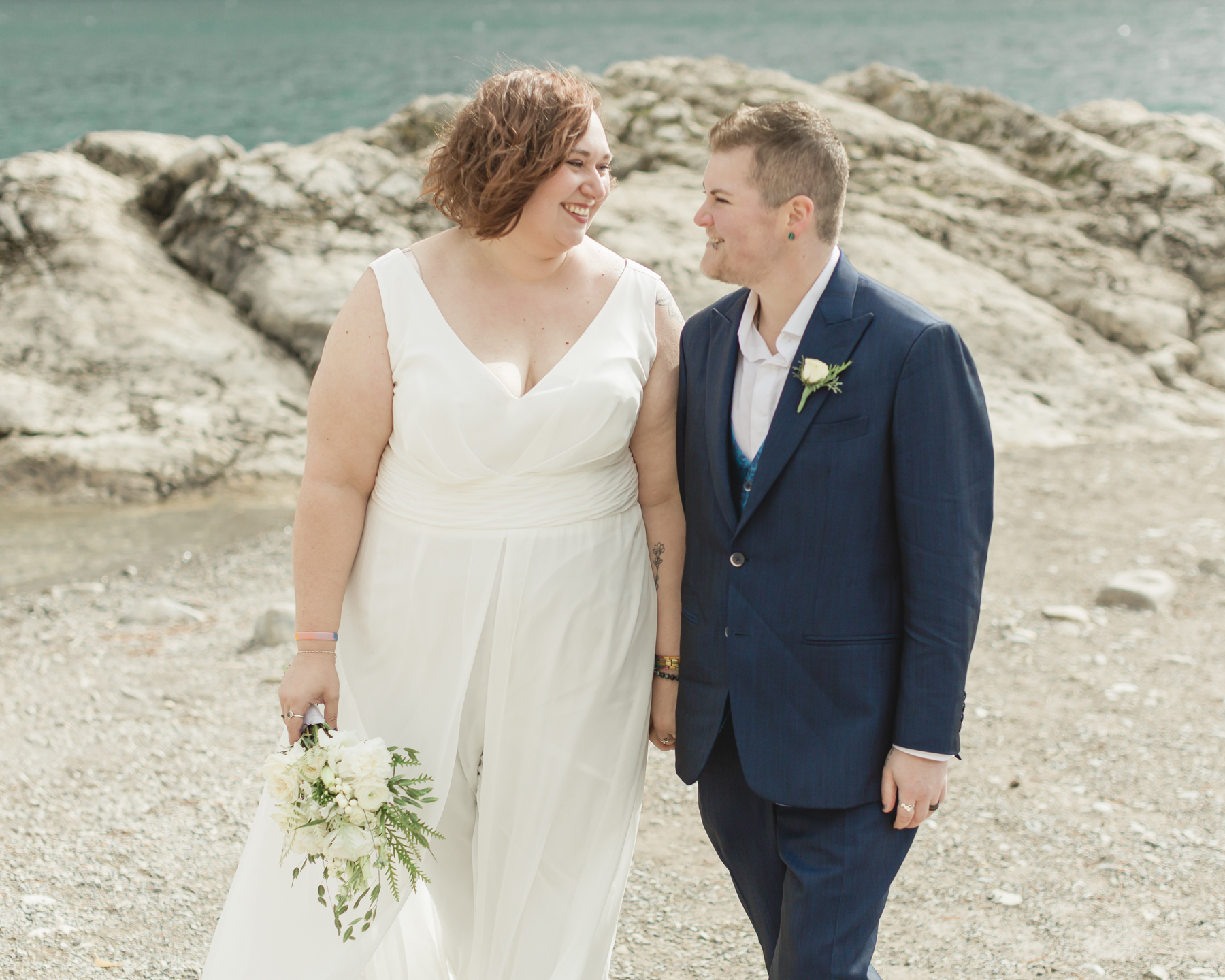 A LGBTQIA+ couple after their wedding exploring Lake Minnewanka 