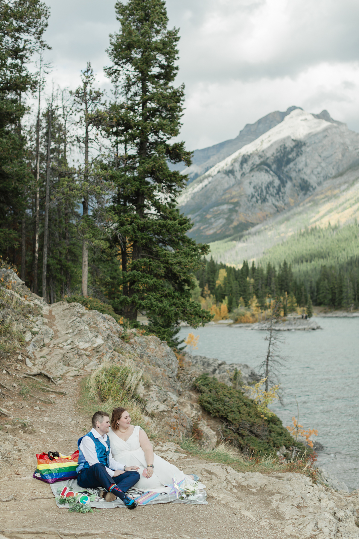 A LGBTQIA+ enjoying a picnic together after their elopement at Lake Minnewanka 