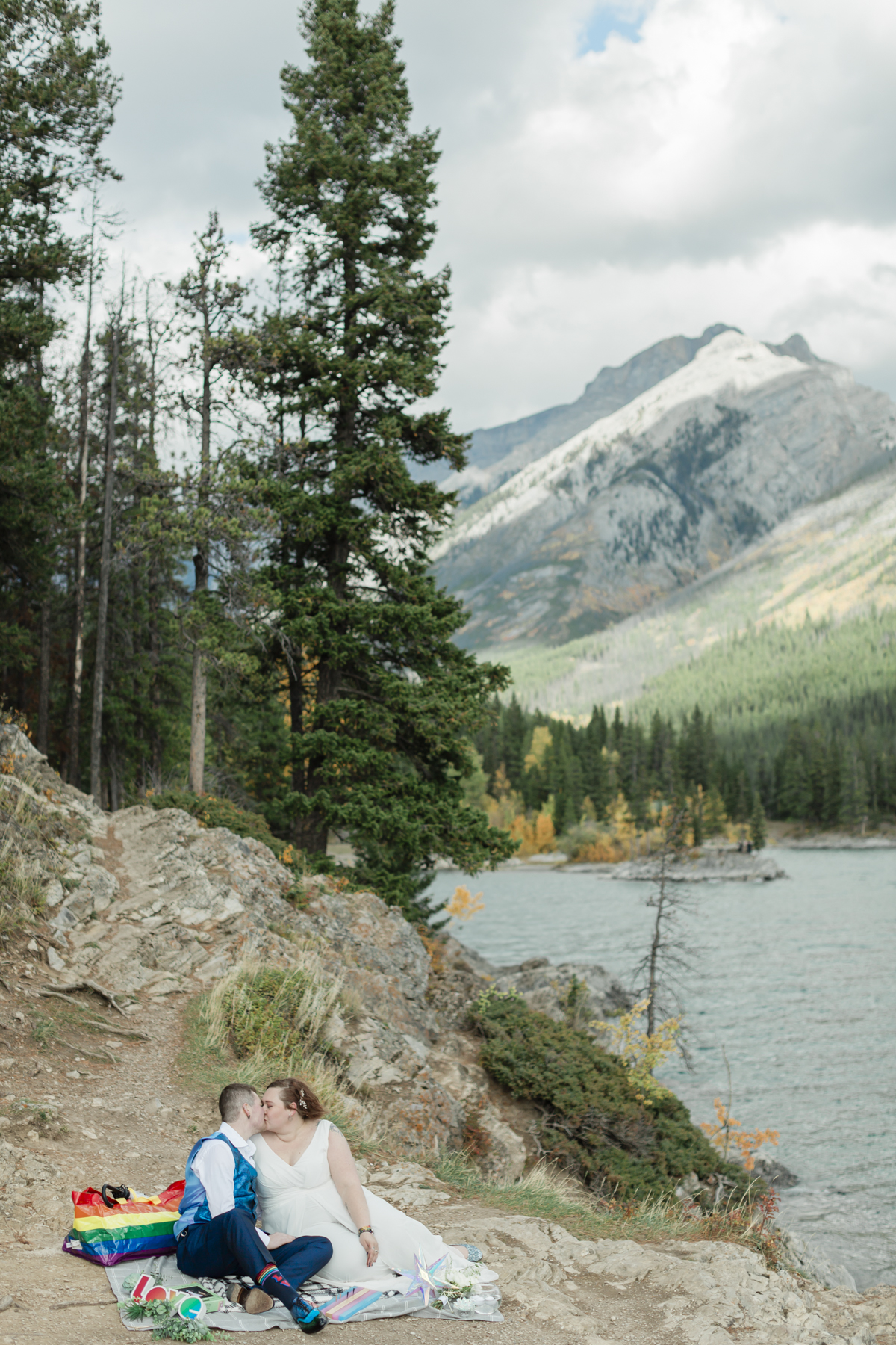 A LGBTQIA+ enjoying a picnic together after their elopement at Lake Minnewanka 