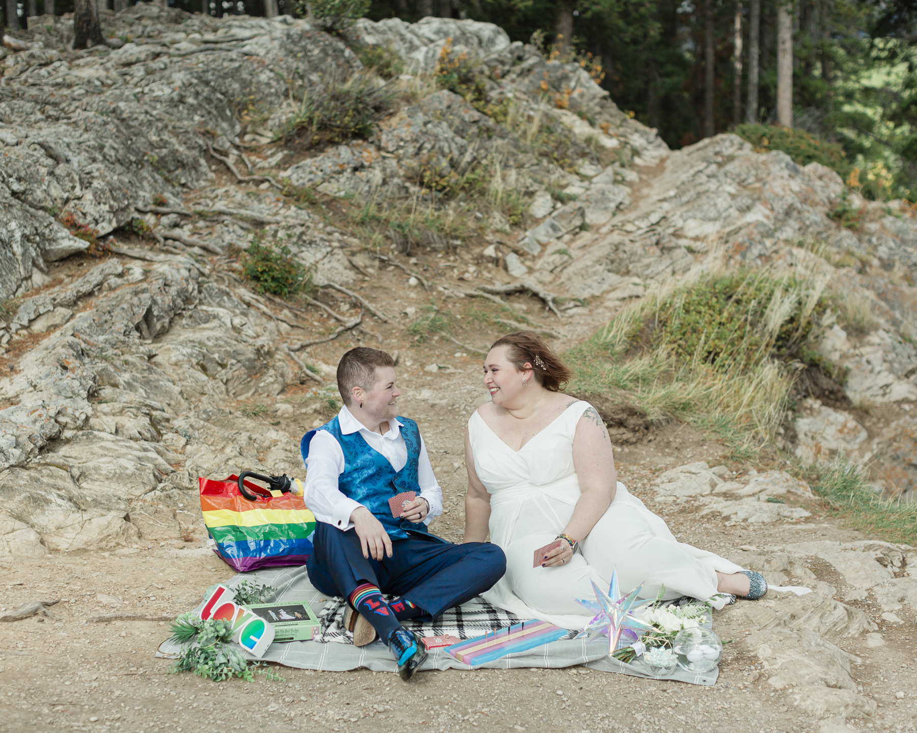 A LGBTQIA+ enjoying a picnic together after their elopement at Lake Minnewanka 