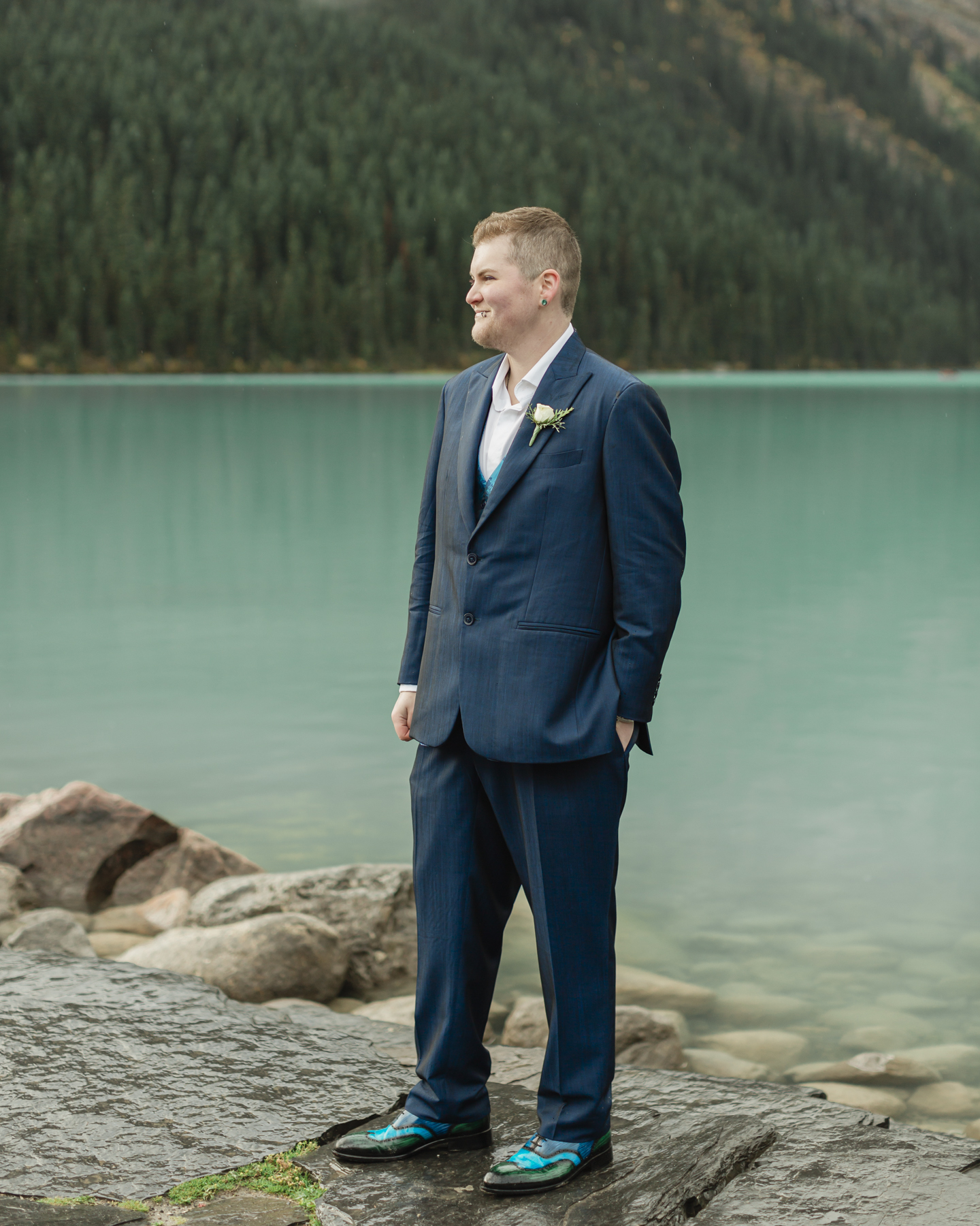 A portrait of a transmasc nonbinary person that just got married at Lake Louise