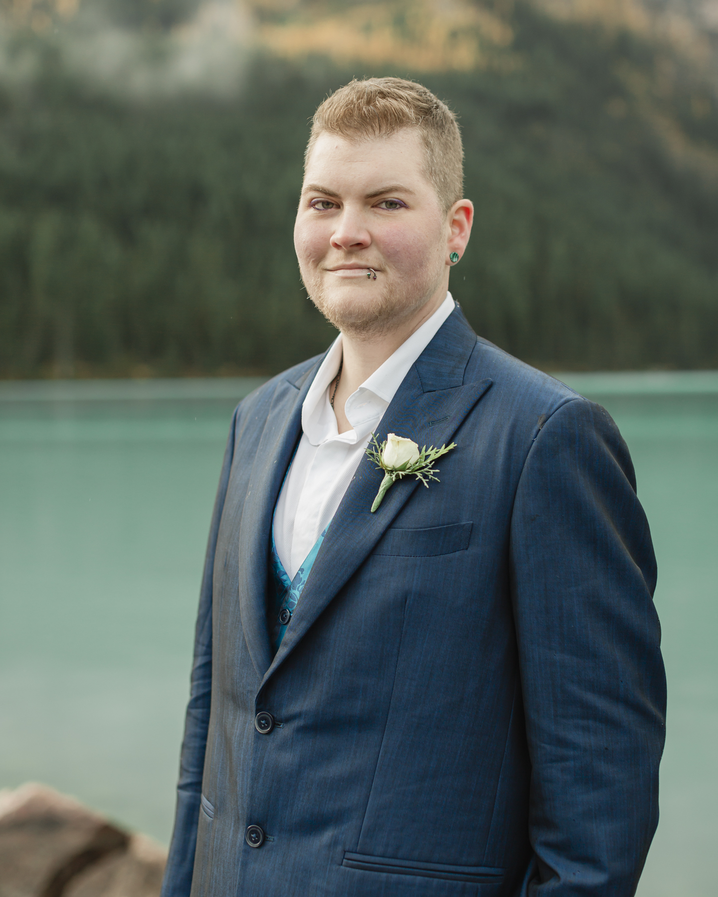 A portrait of a transmasc nonbinary person that just got married at Lake Louise