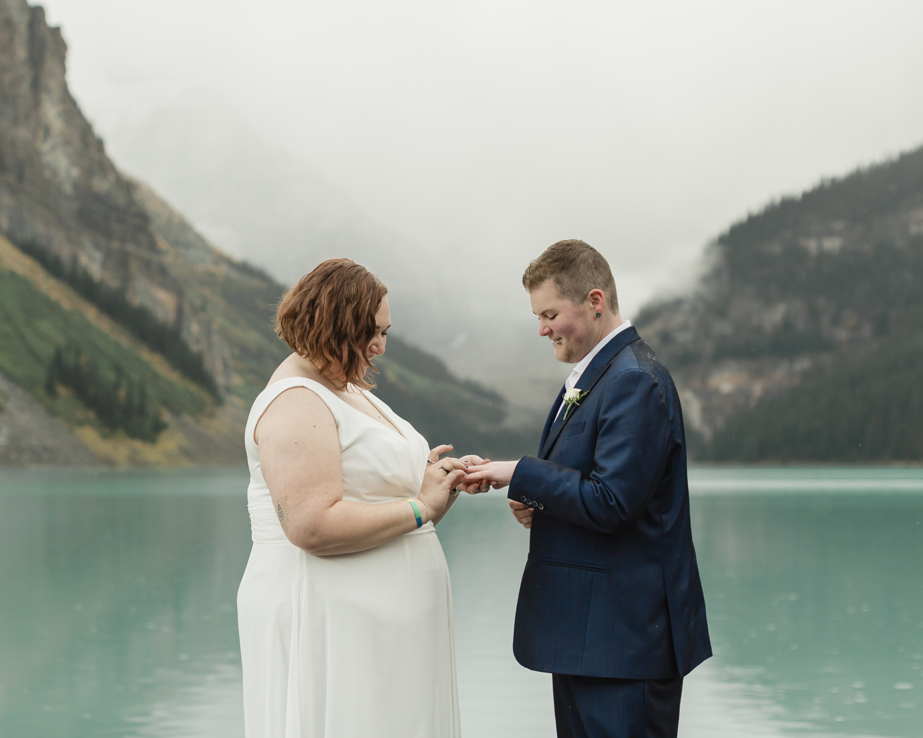 A queer couple exchanging rings at Lake Louise in Banff 