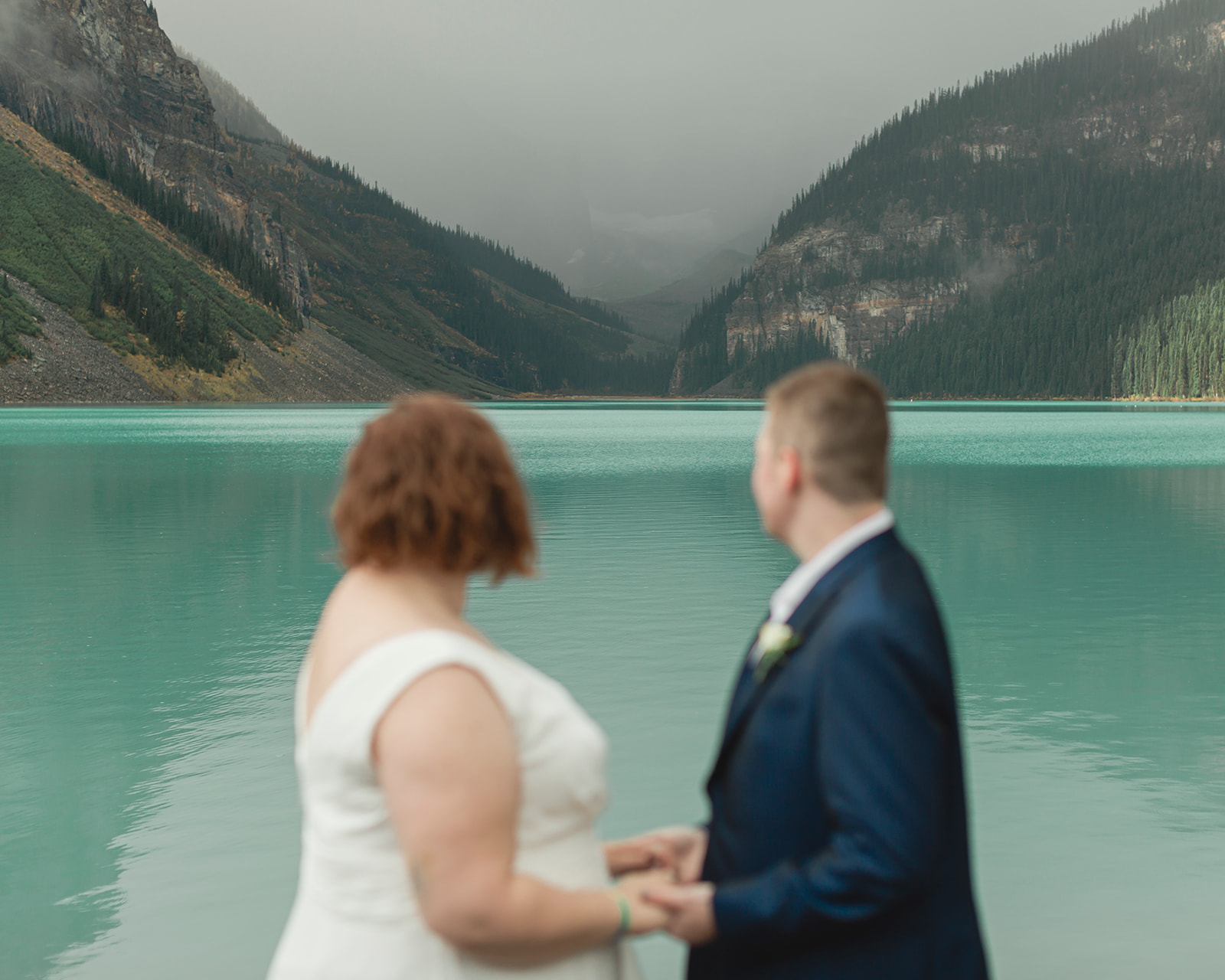 Callen & Alexa hold hands as they're eloping at Lake Louise