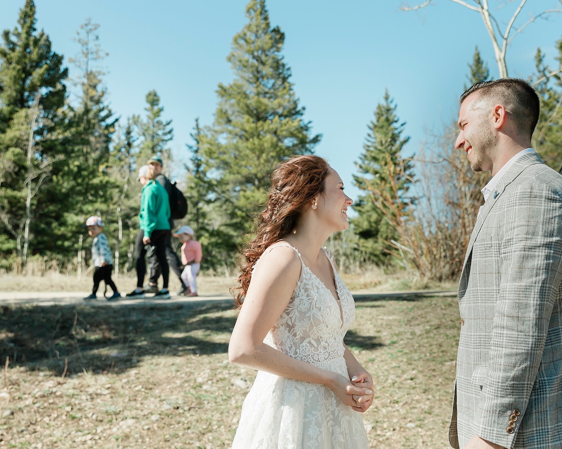 A couple eloping laugh together with tourists in the background