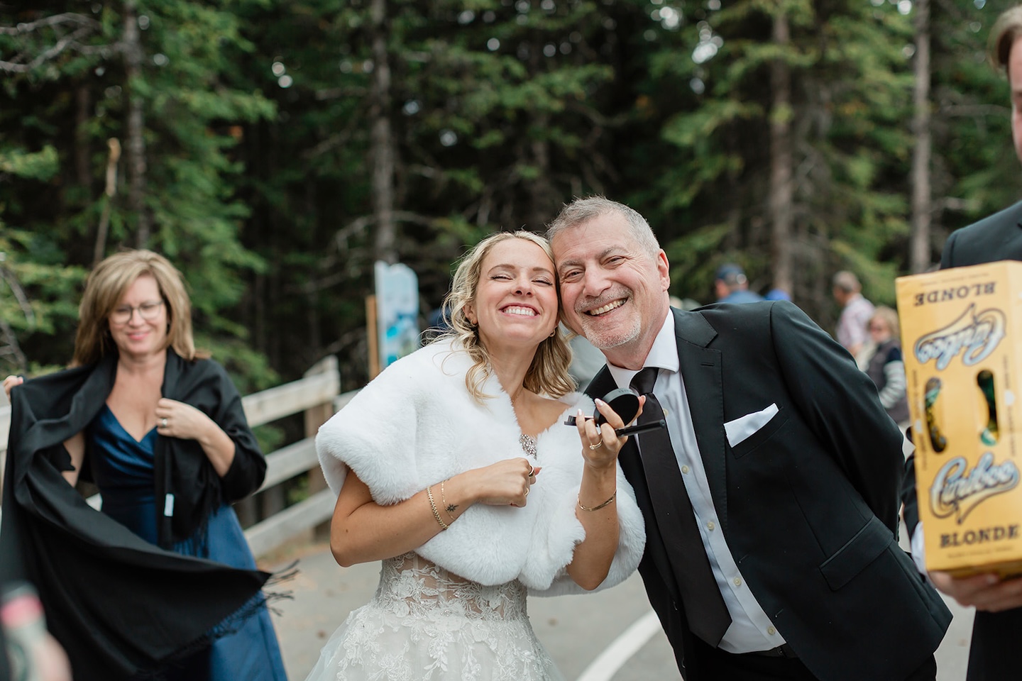 a bride poses with her family during her kananaskis elopement with hikers in the background