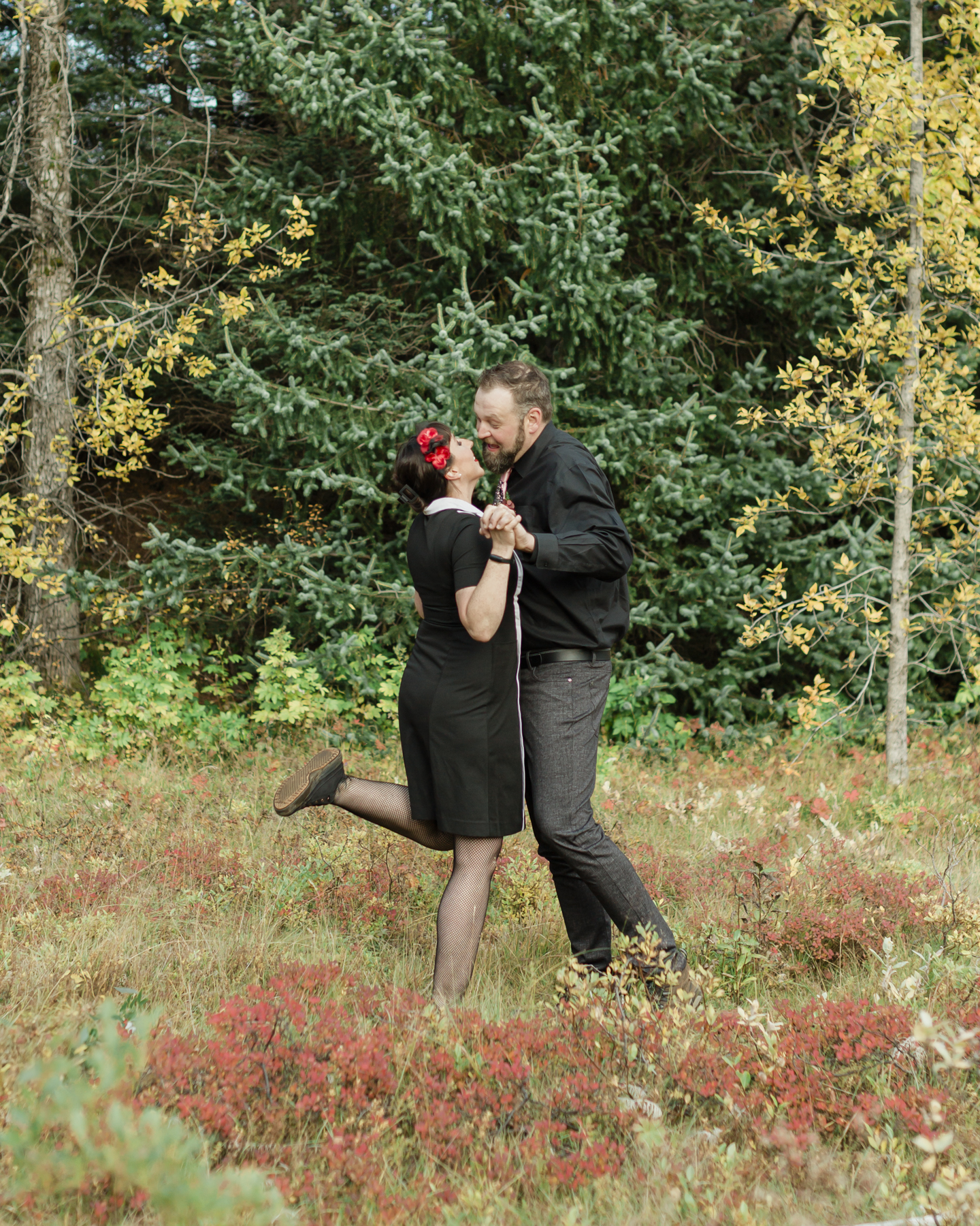 Wedding couple's portraits in the Iceland forest, there are green and yellow trees are behind them