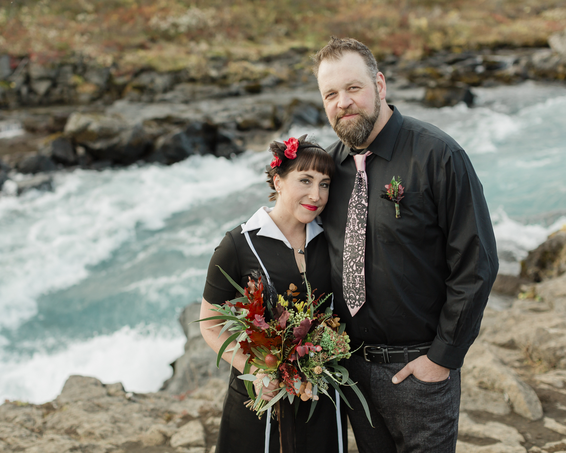 Elopement couple's portraits in front of a running waterfall in Iceland on the Golden Circle