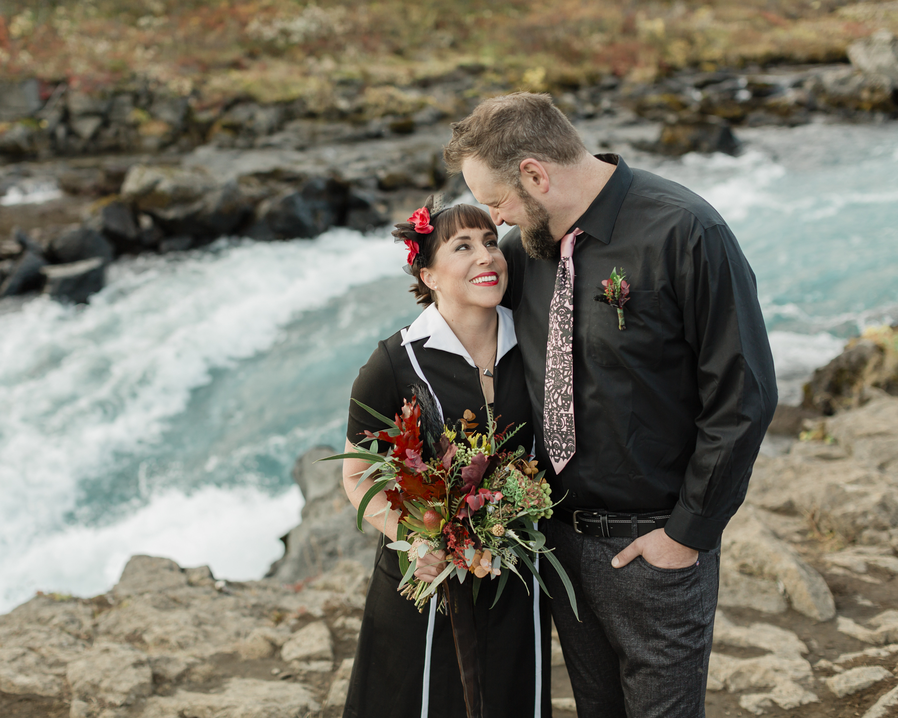 Virginia holding a unique bouquet of red flowers for their iceland elopement