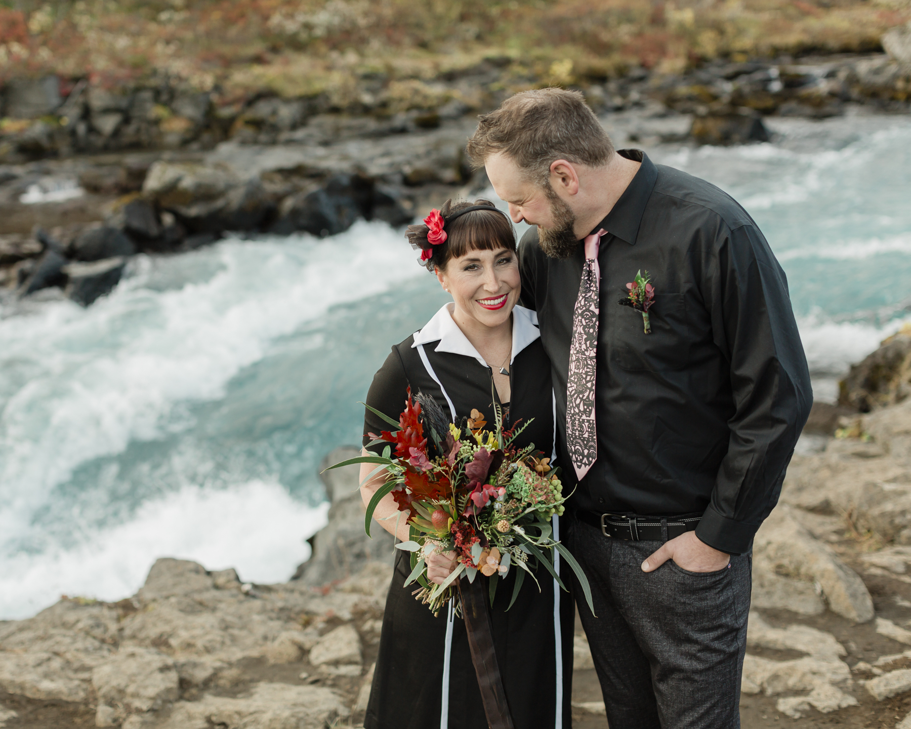 Elopement couple's portraits in front of a running waterfall in Iceland on the Golden Circle