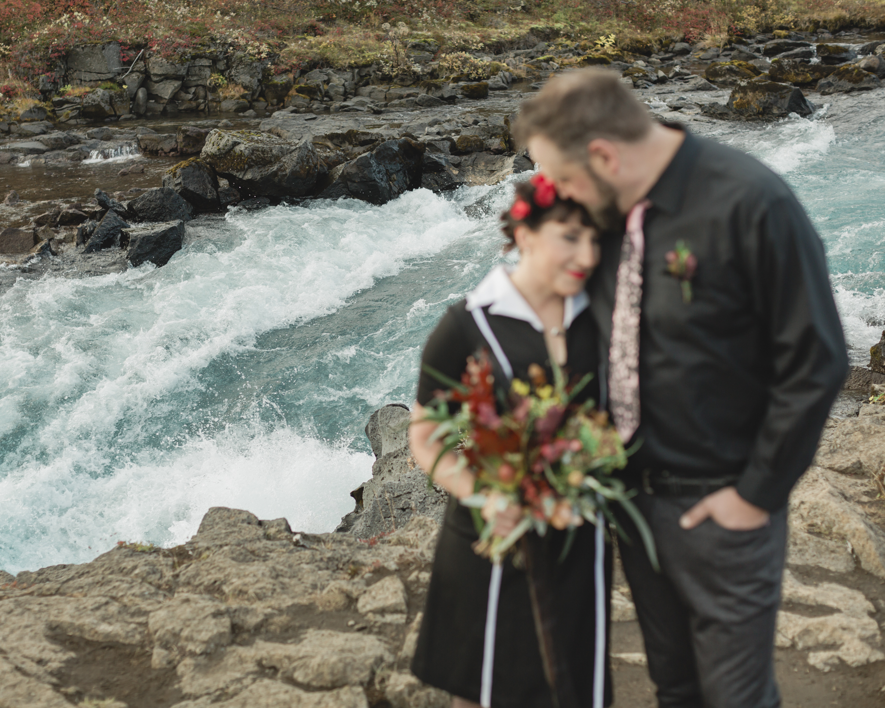 Elopement couple's portraits in front of a running waterfall in Iceland on the Golden Circle