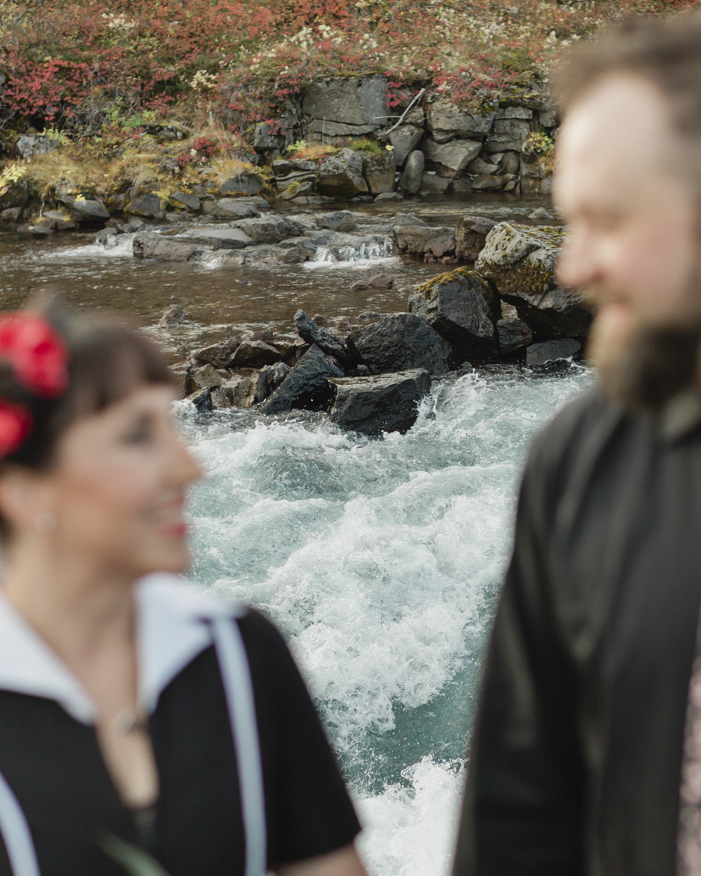 Elopement couple's portraits in front of a running waterfall in Iceland on the Golden Circle