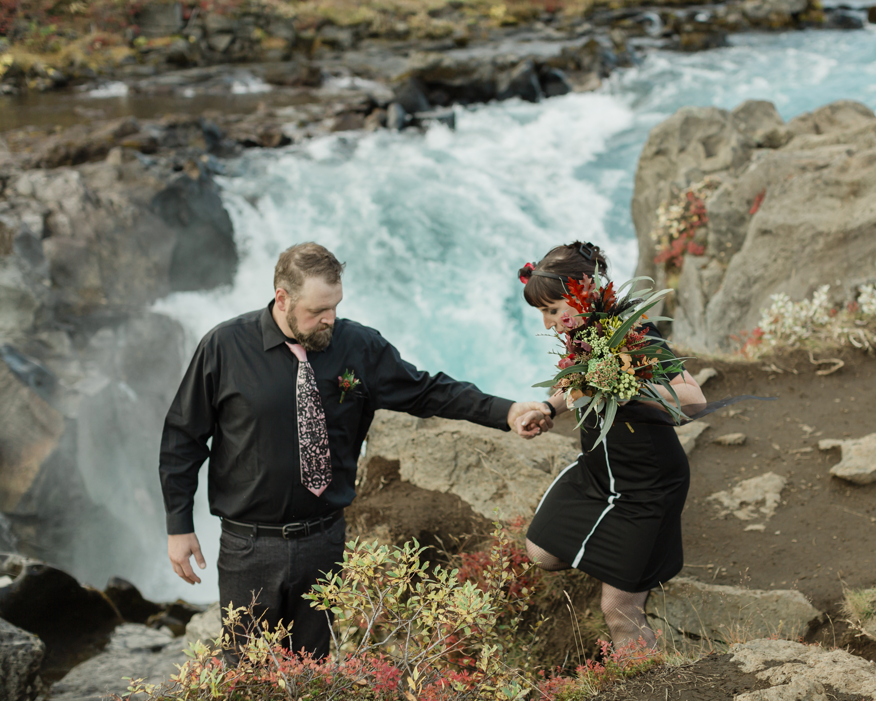 Elopement couple's portraits in front of a running waterfall in Iceland on the Golden Circle