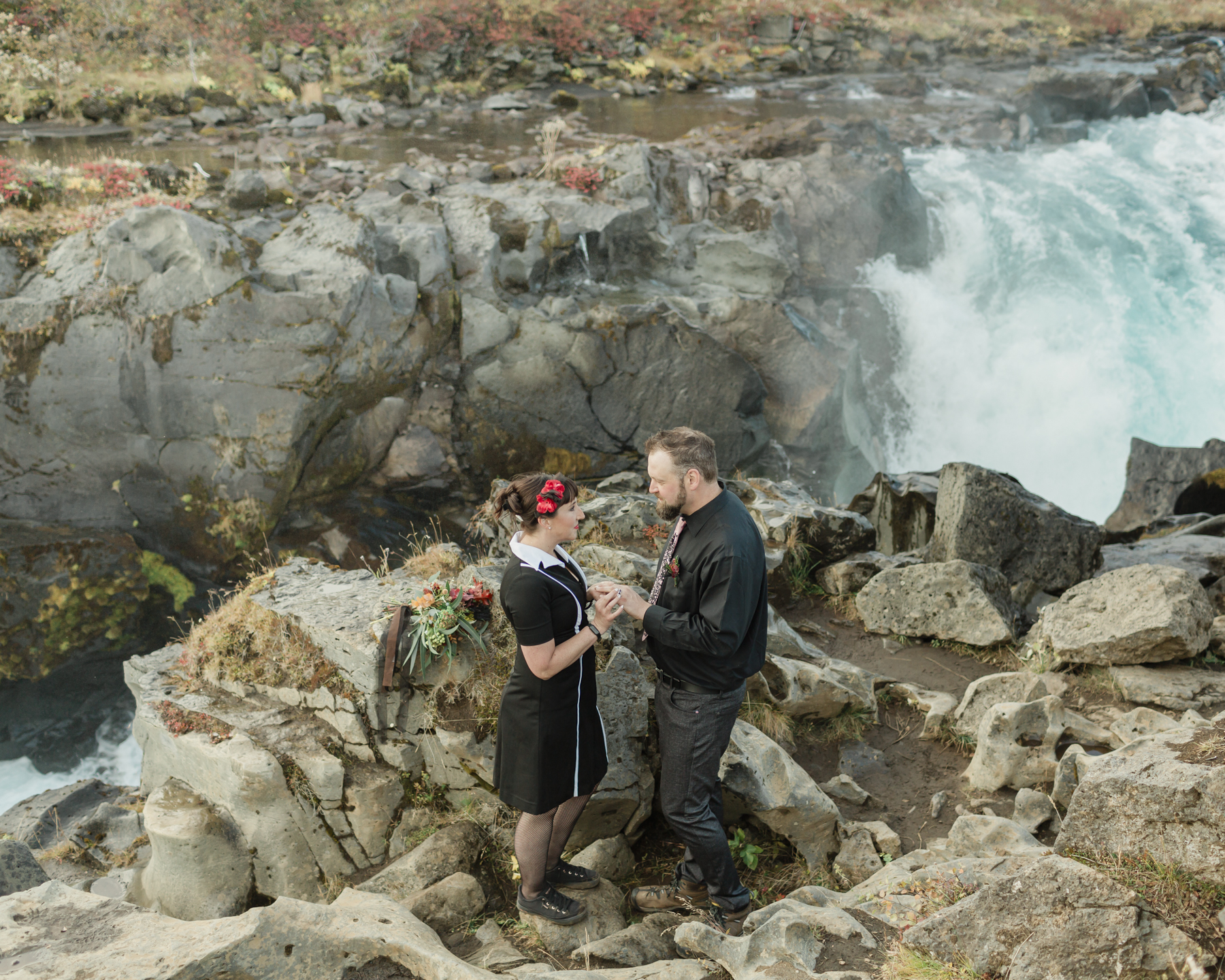 Virginia and Derek exchanging rings during their elopement ceremony in front of a running waterfall in Iceland on the Golden Circle