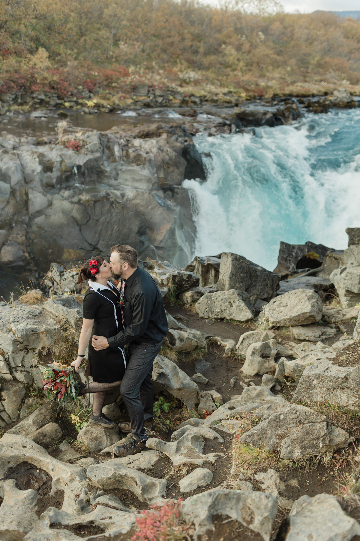 Virginia and Derek kissing after their elopement ceremony in front of a running waterfall in Iceland on the Golden Circle