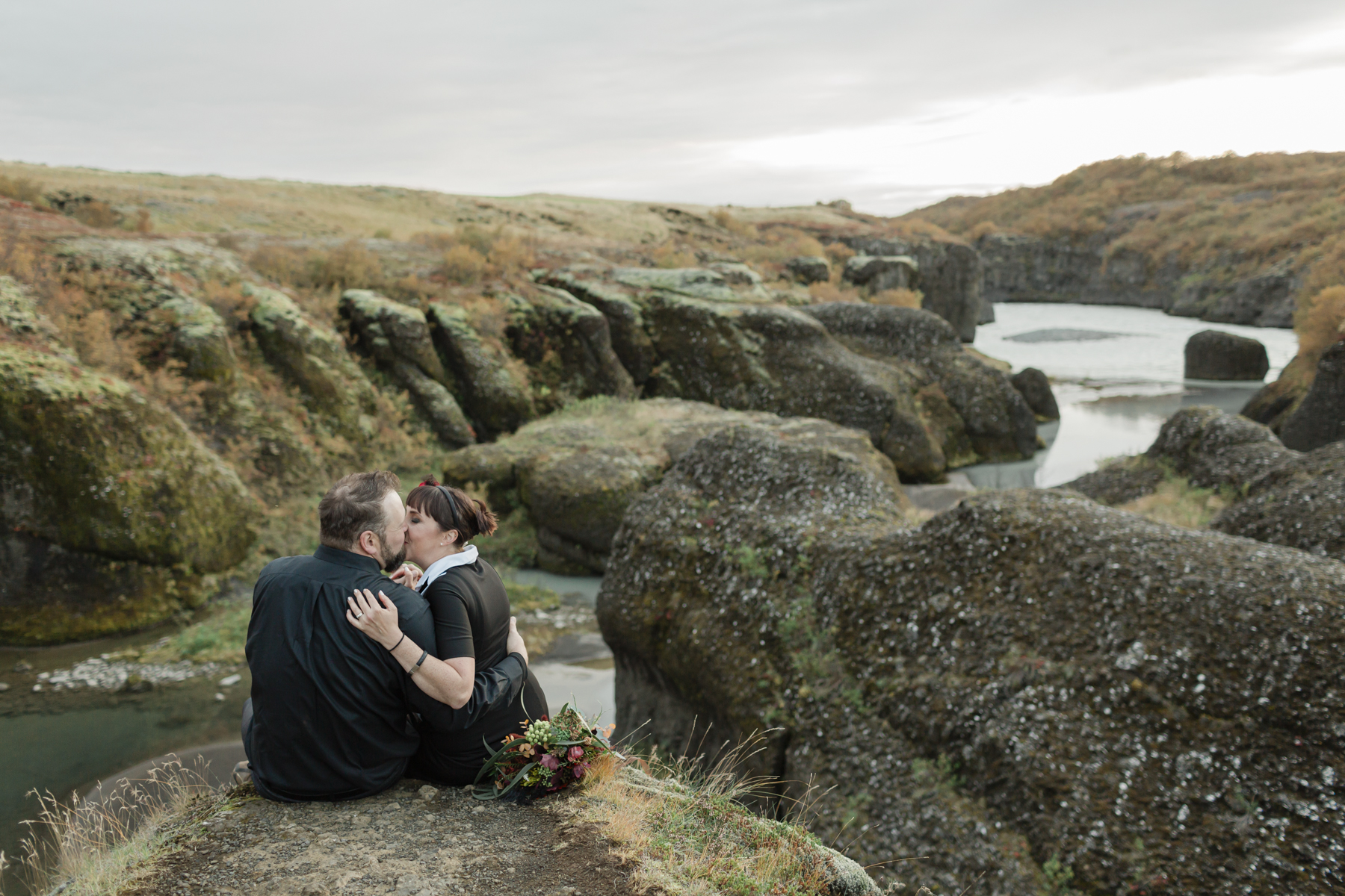 Virginia and Derek kissing in front of an Iceland canyon and enjoying the view after their elopement ceremony 