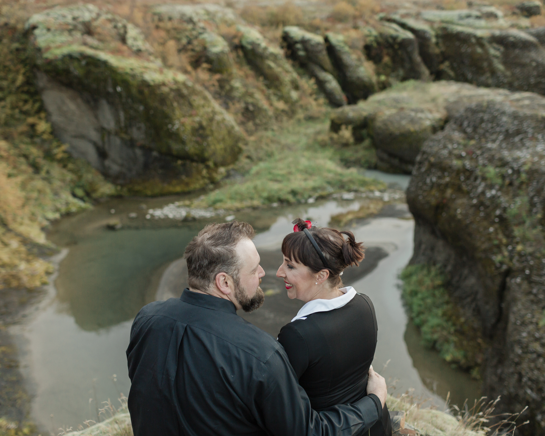 Virginia and Derek looking at each other in front of an Iceland canyon and enjoying the view after their elopement ceremony 