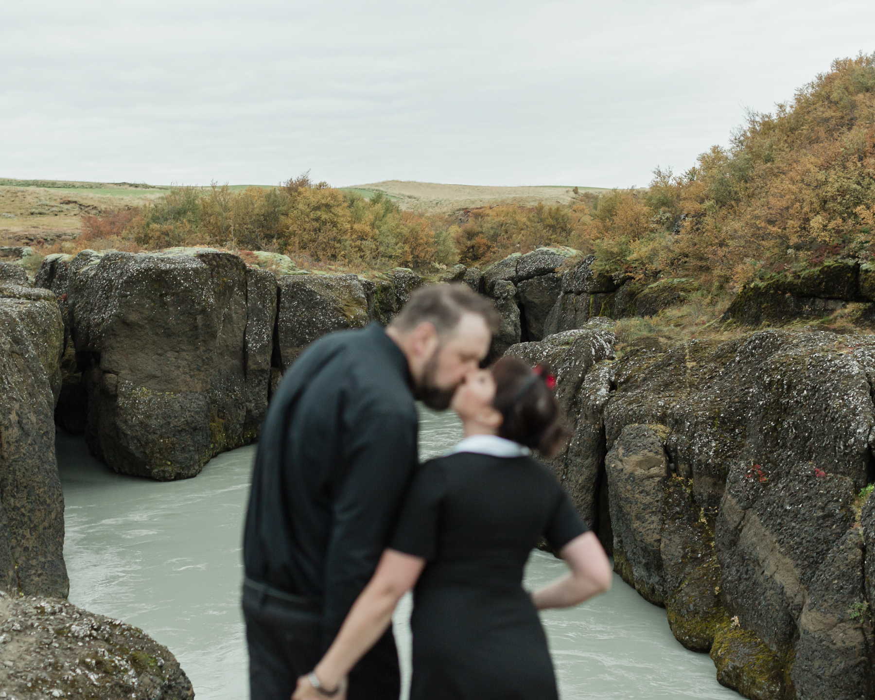 Virginia and Derek kissing in front of a canyon in the Golden Circle