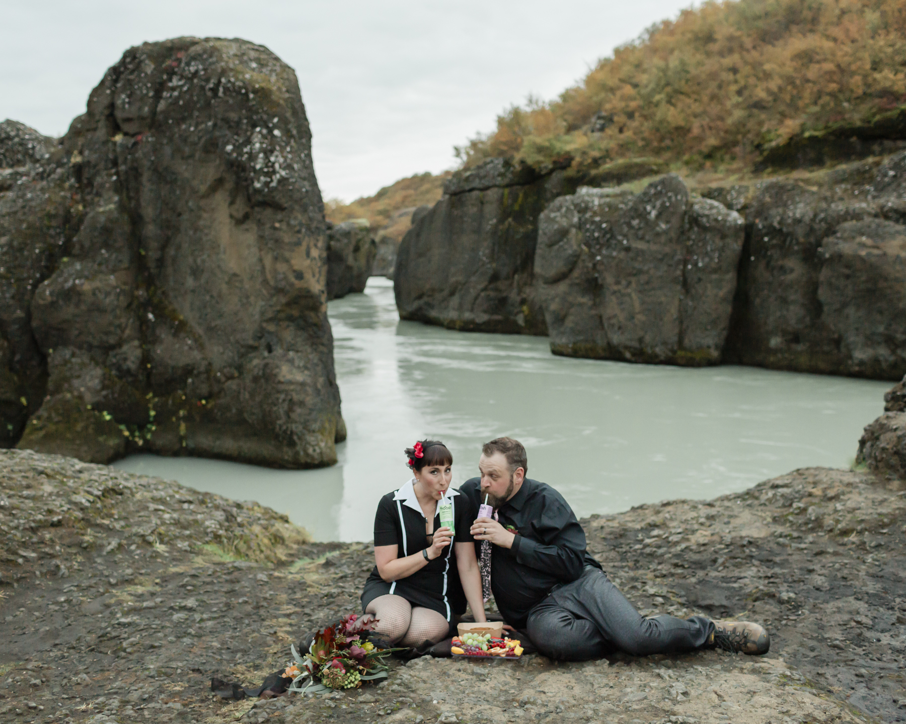 Virginia and Derek having a picnic and drinking smoothies in front of a canyon in the Golden Circle