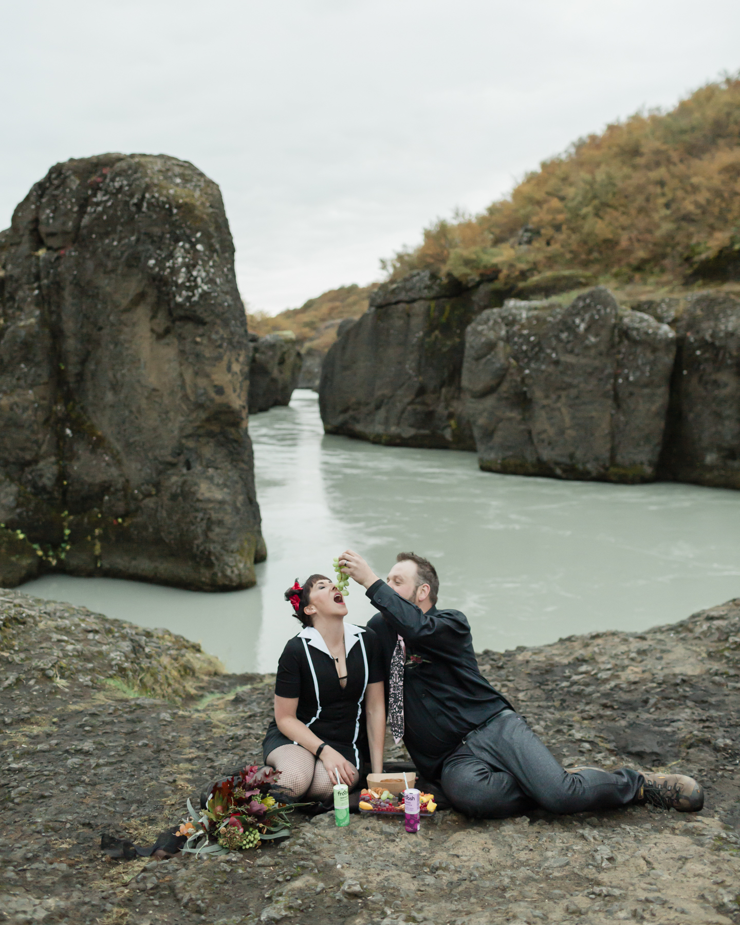 Virginia and Derek having a picnic and eating grapes in front of a canyon in the Golden Circle