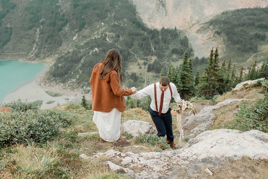 Emily & John hiking with emily in a sweater during their Nordegg elopement