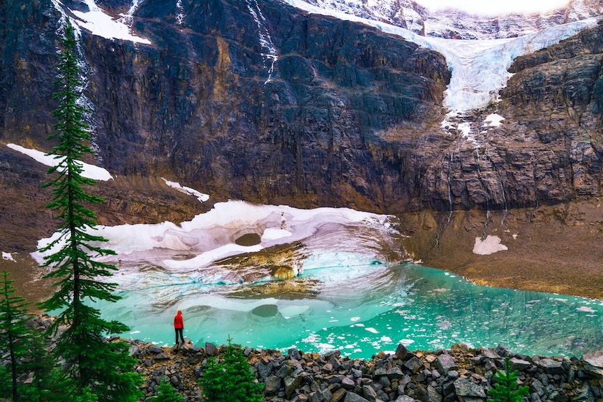 person standing near glacial lake in jasper national park