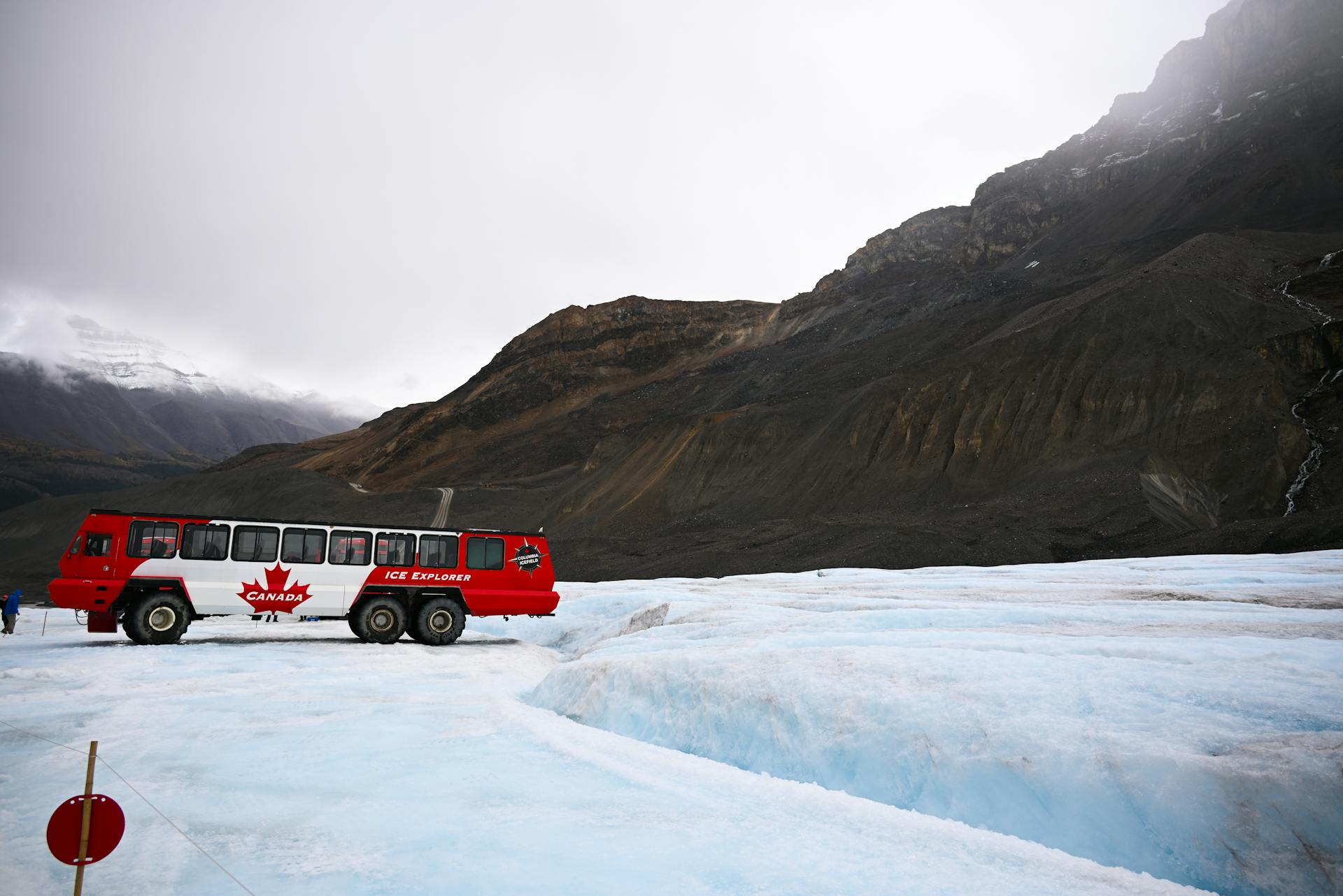 red ice explorer bus parked on top of a glacier in banff