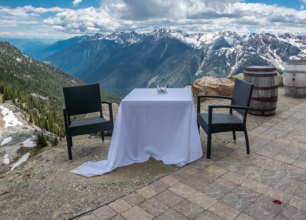 A table setup at the edge of a cliff at the eagle eye restaurant, at the top of kicking horse mountain resort