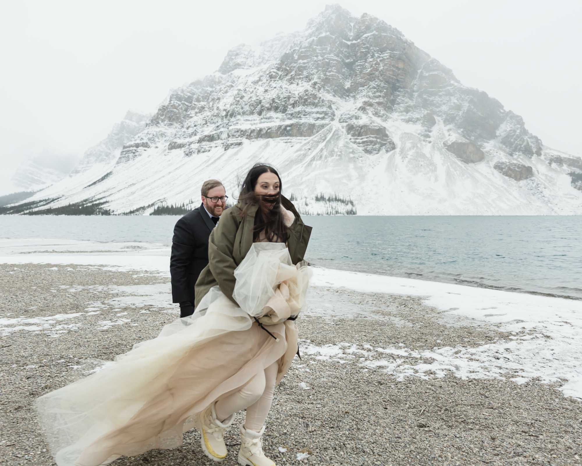 Wedding couple in the wind at Bow Lake in Banff National Park during their Elopement