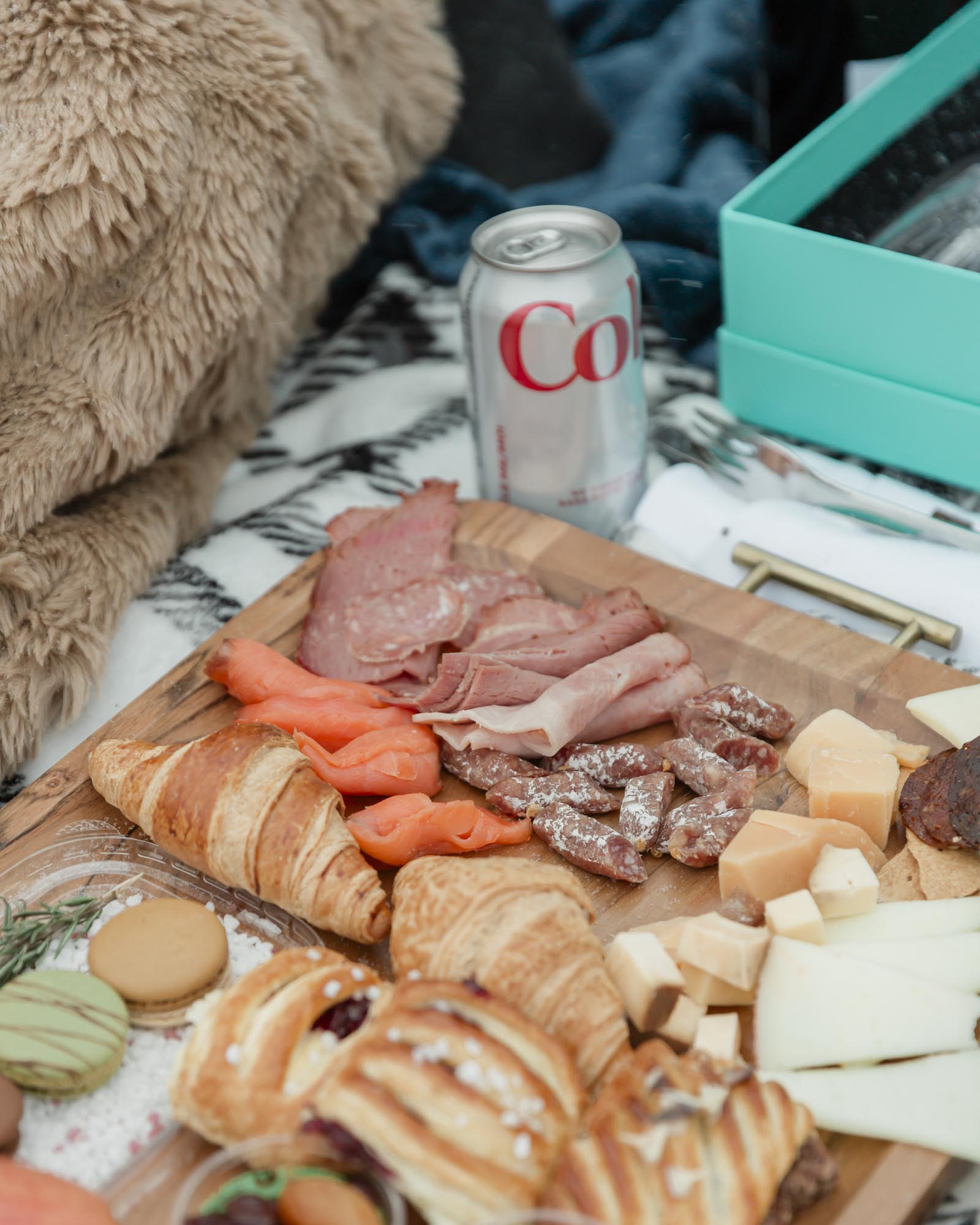 Wedding couple enjoying a winter picnic at Bow Lake in Banff National Park during their Elopement, featuring diet coke and a charcuterie board