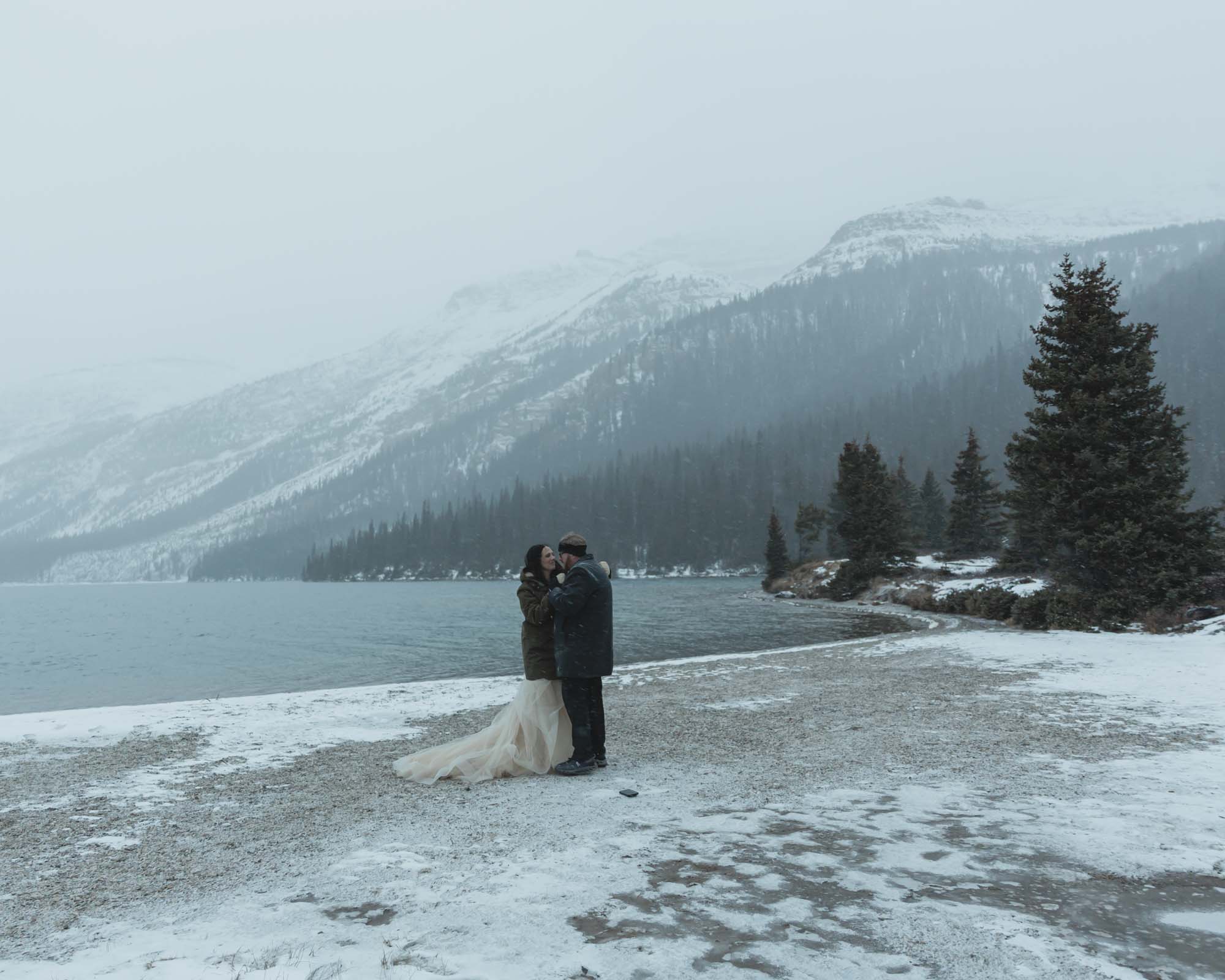 Wedding couple having their first dance at Bow Lake in Banff National Park during their Elopement in the winter at sunset