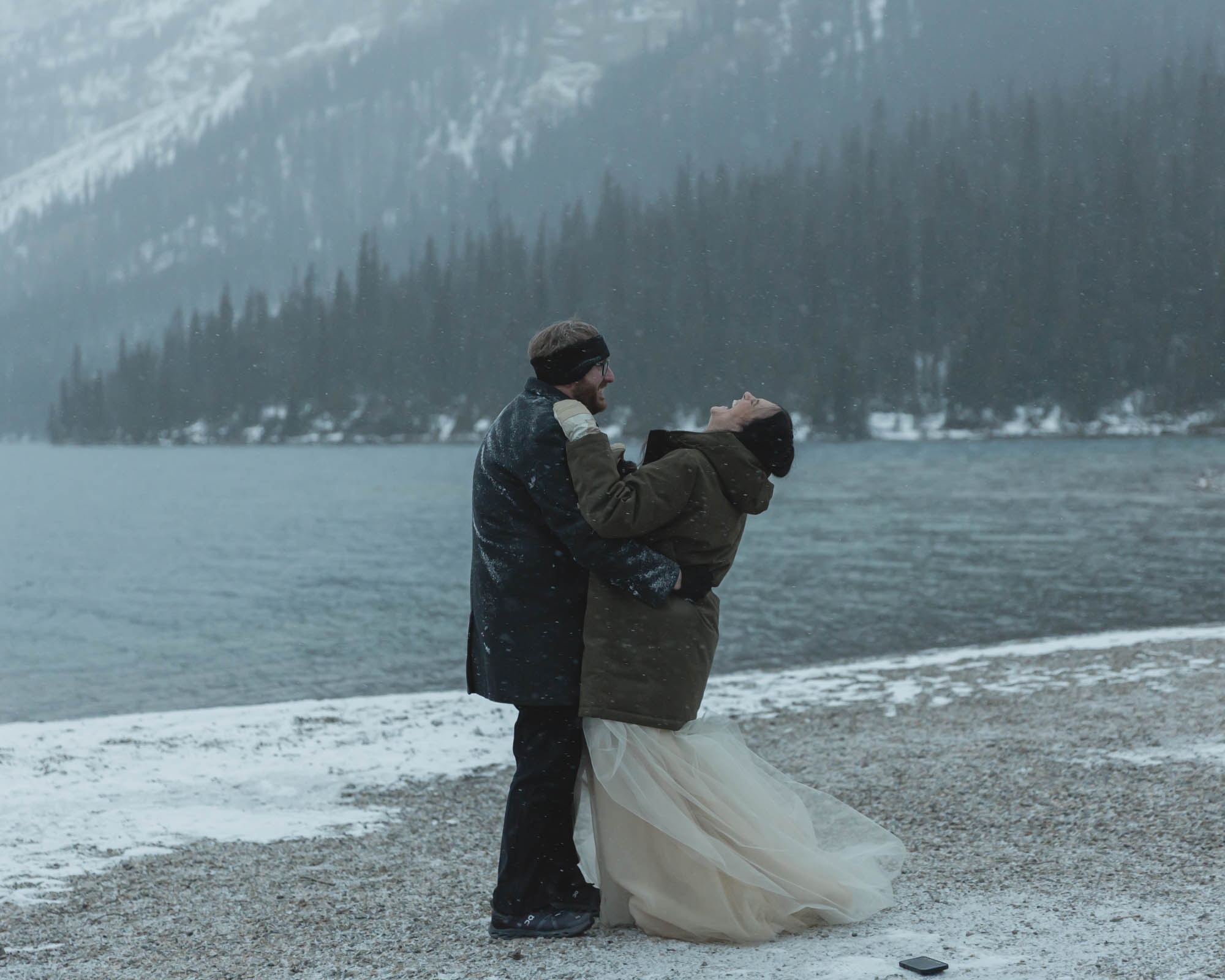 Wedding couple having their first dance at Bow Lake in Banff National Park during their Elopement in the winter at sunset