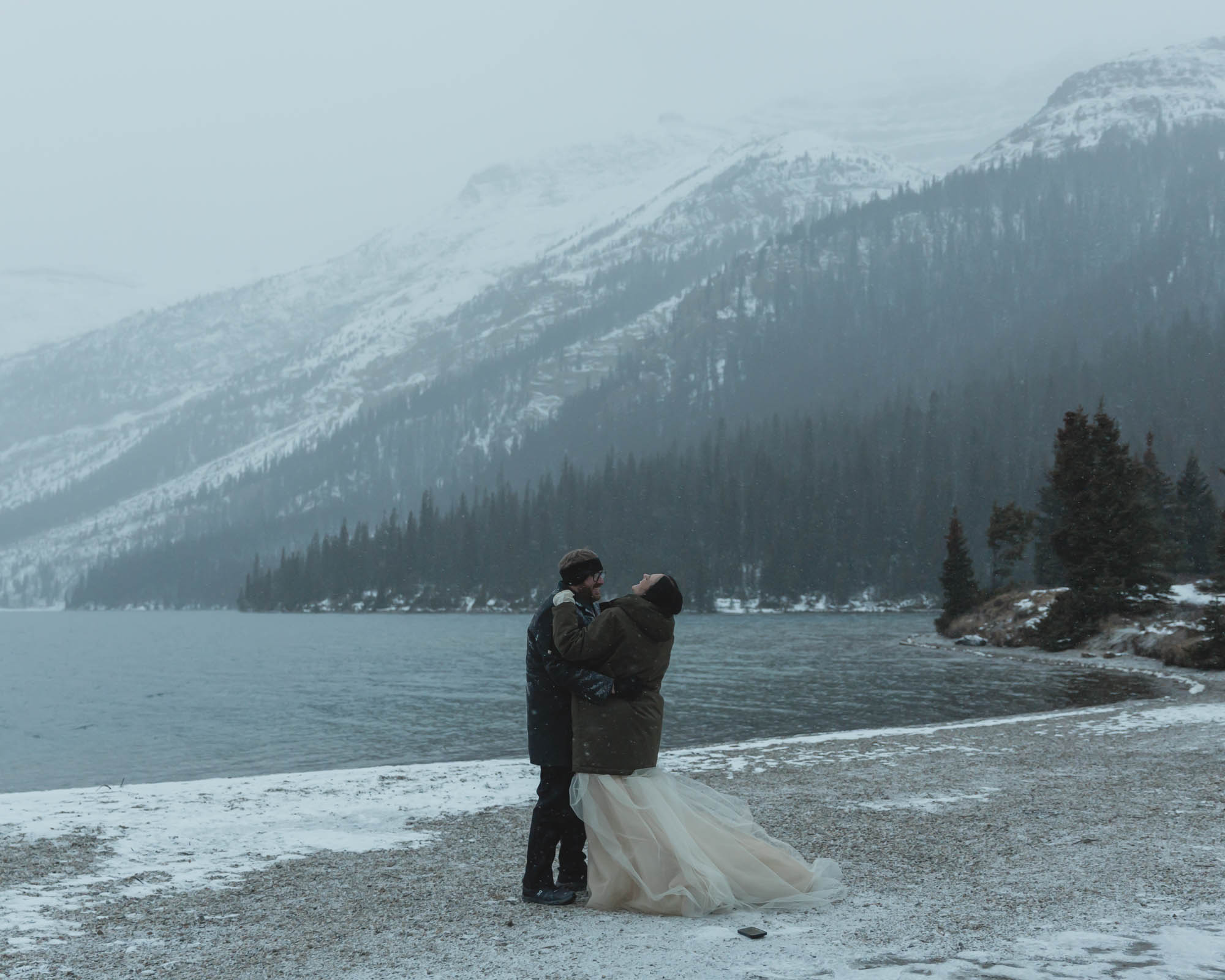Wedding couple having their first dance at Bow Lake in Banff National Park during their Elopement in the winter at sunset