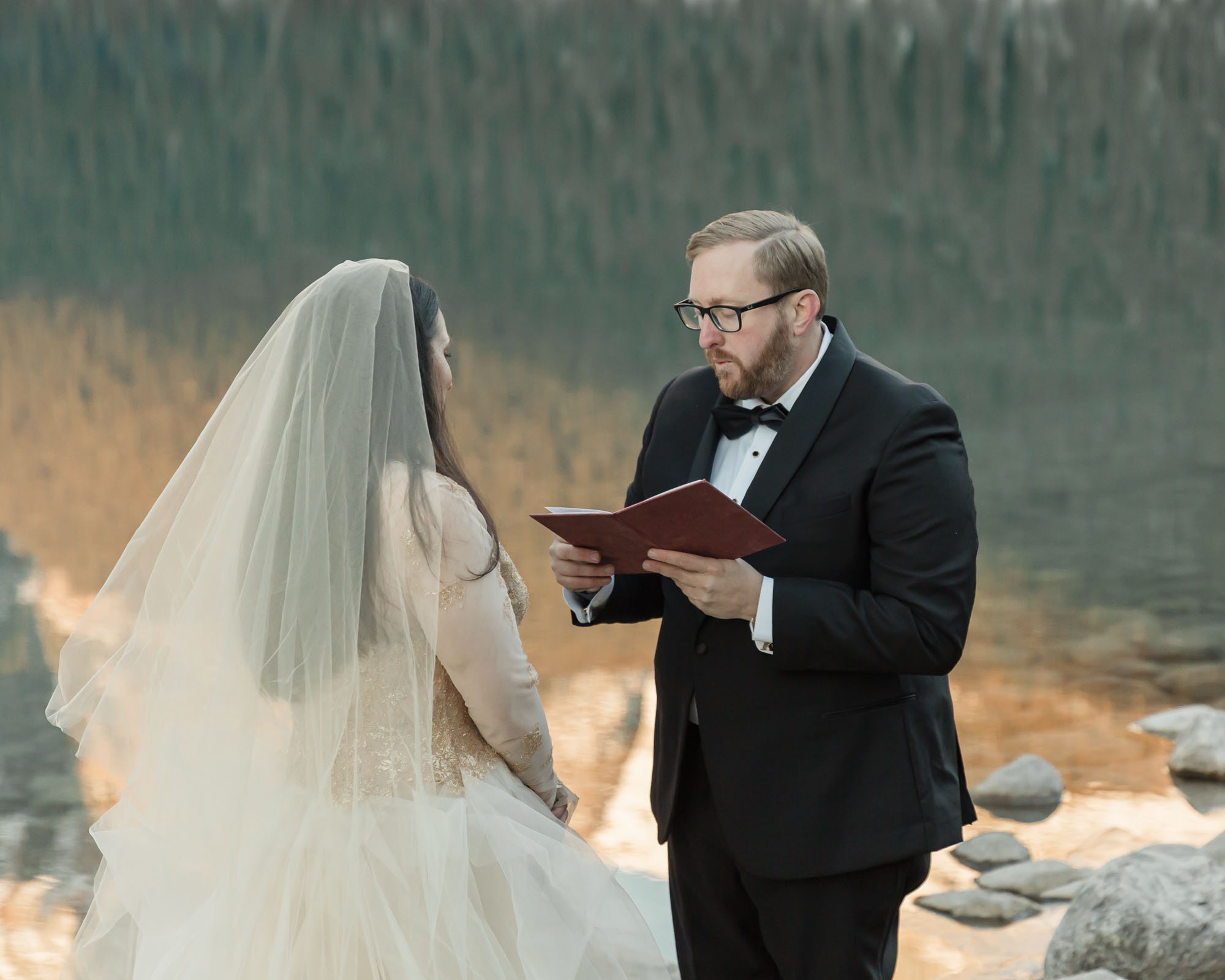 A Lake louise elopement, the couple is saying their vows and the bride is emotional