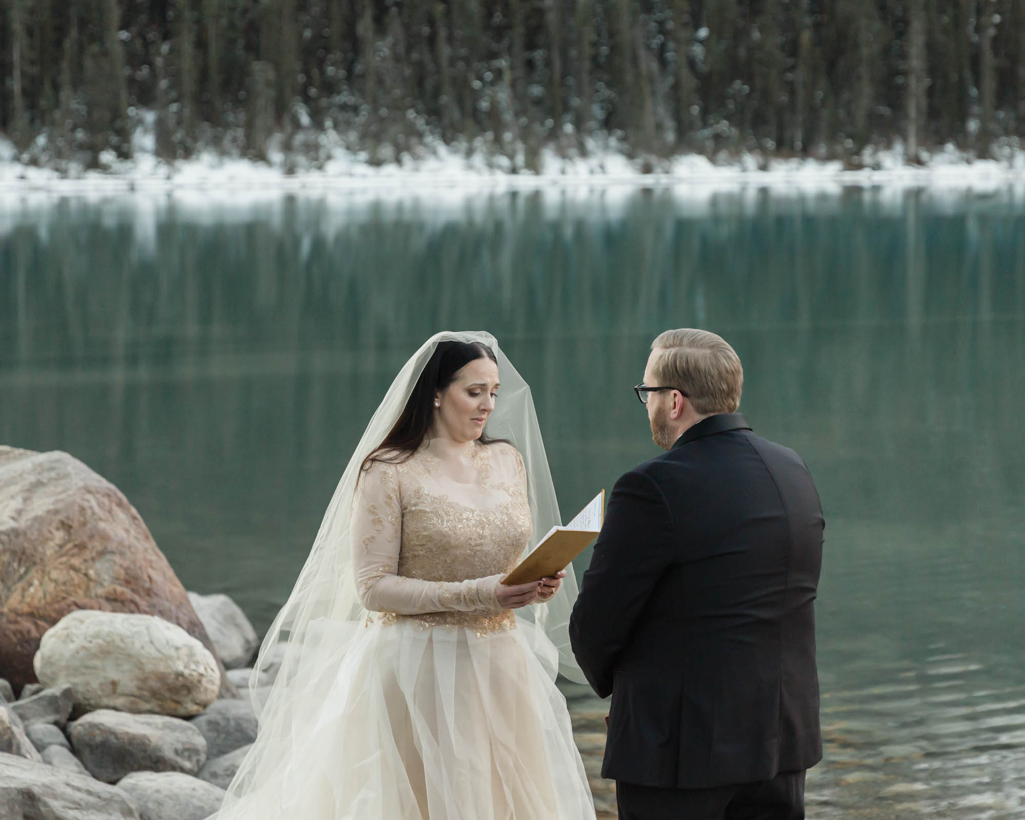 A Lake louise elopement, the couple is saying their vows and the bride is emotional