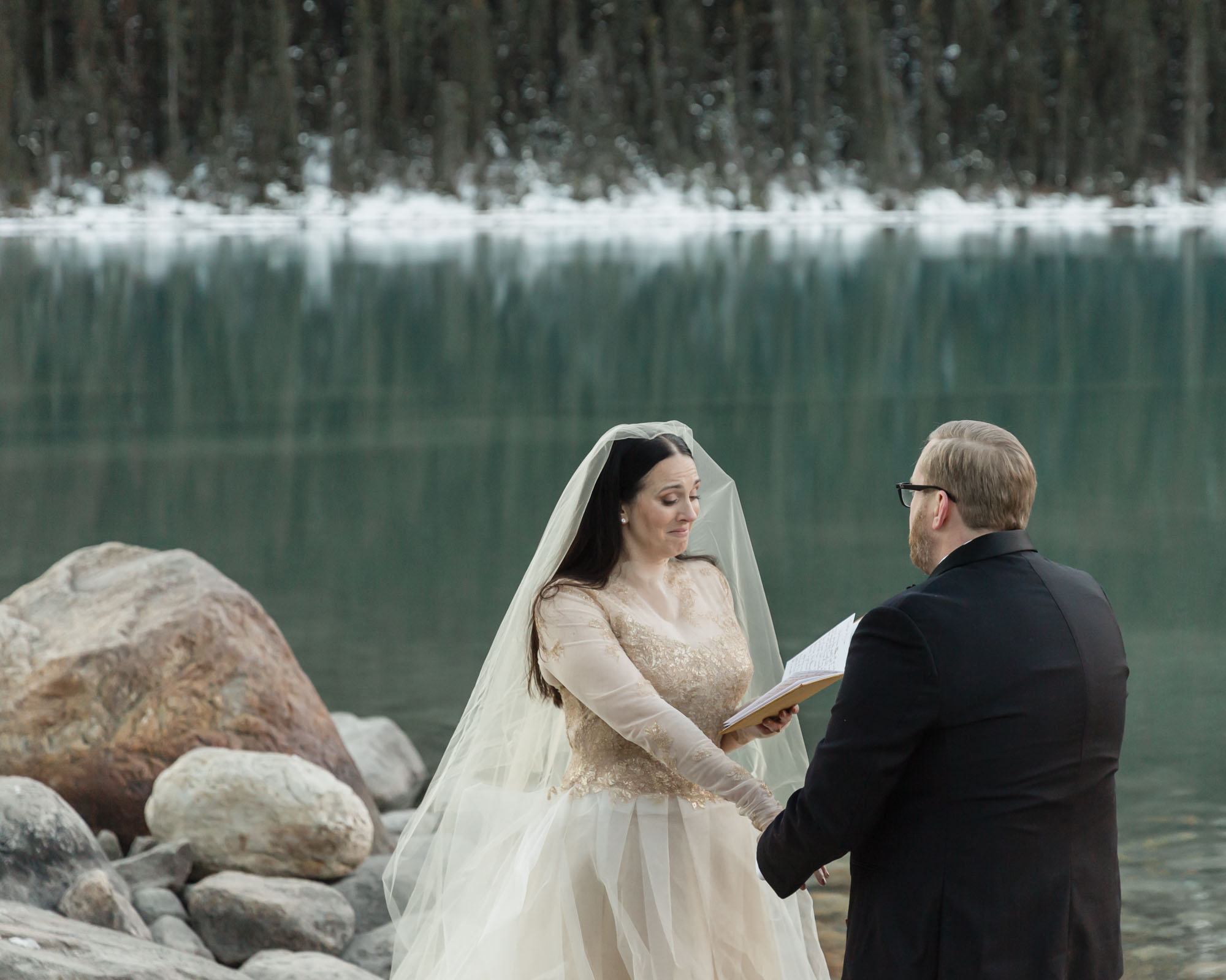 A Lake louise elopement, the couple is saying their vows and the bride is emotional