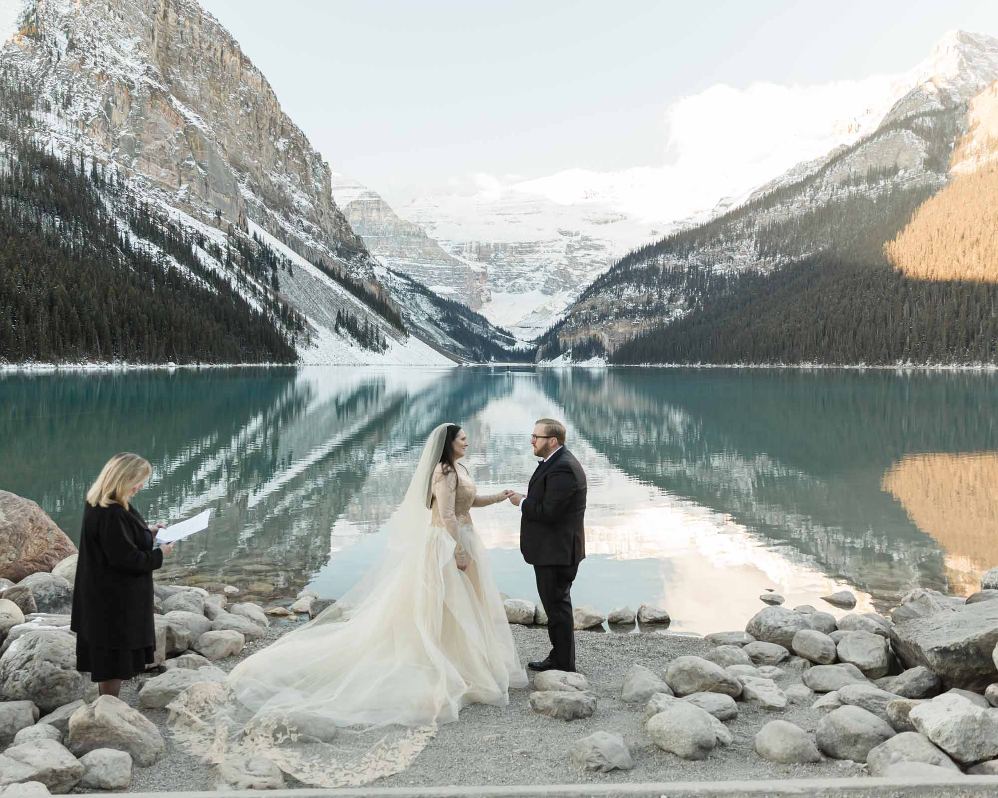 A Lake Louise elopement, the couple is exchanging their wedding rings