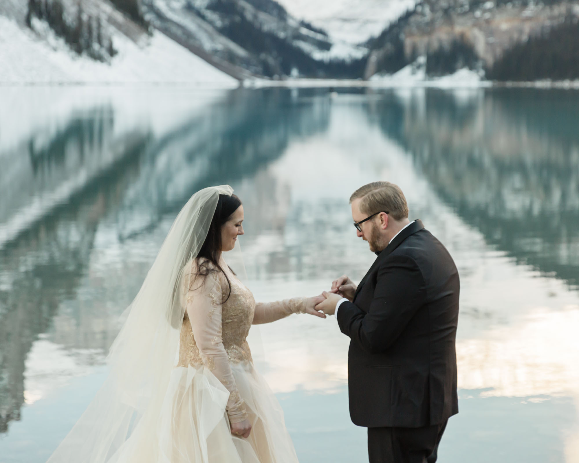 A Lake Louise elopement, the couple is exchanging their wedding rings