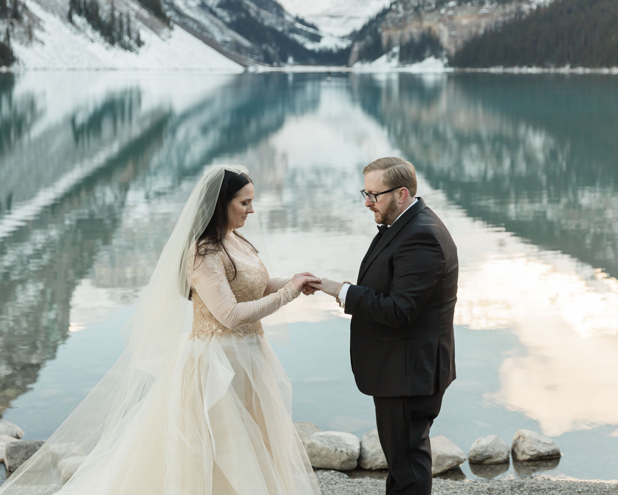 A Lake Louise elopement, the couple is exchanging their wedding rings