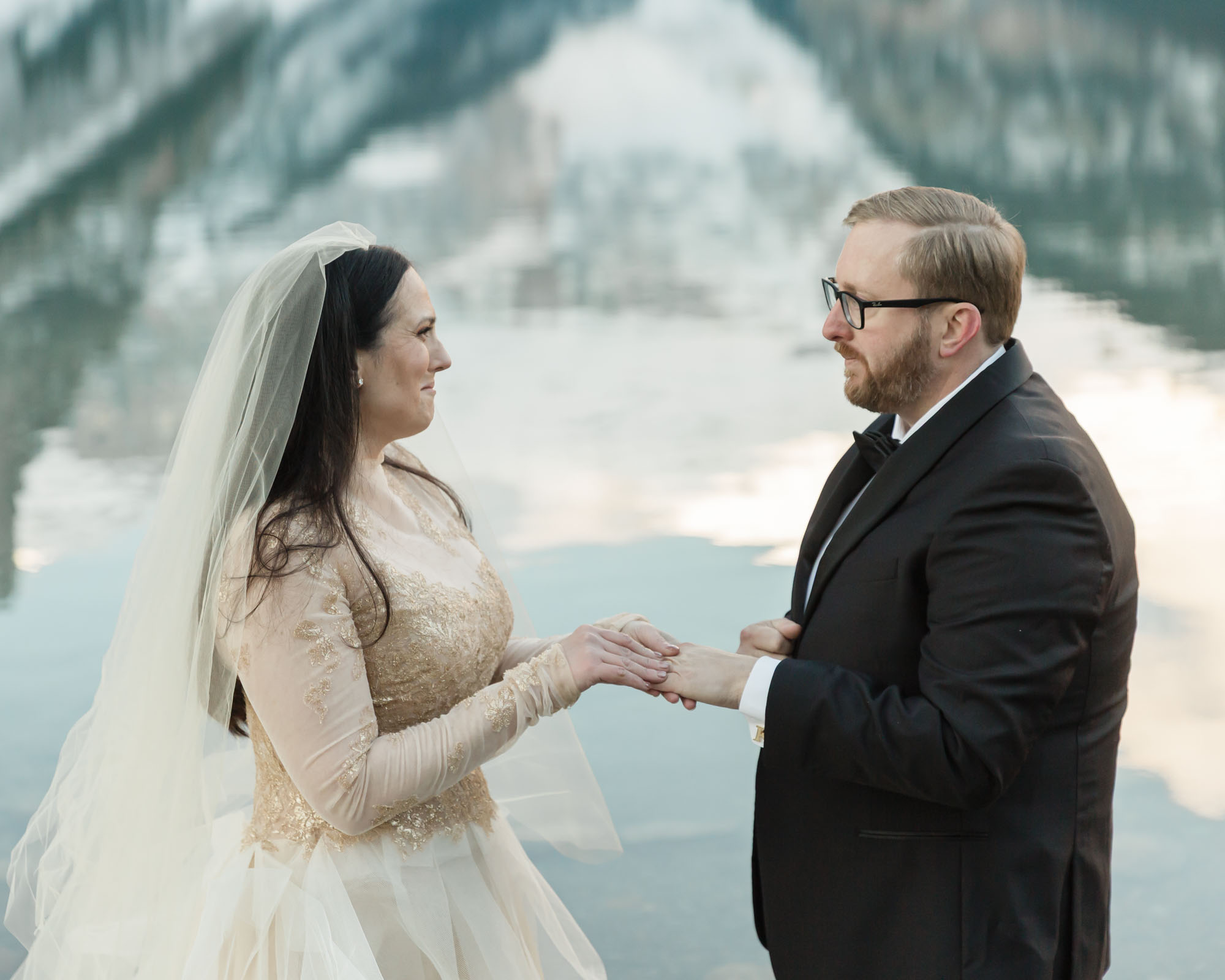 A Lake Louise elopement, the couple is exchanging their wedding rings