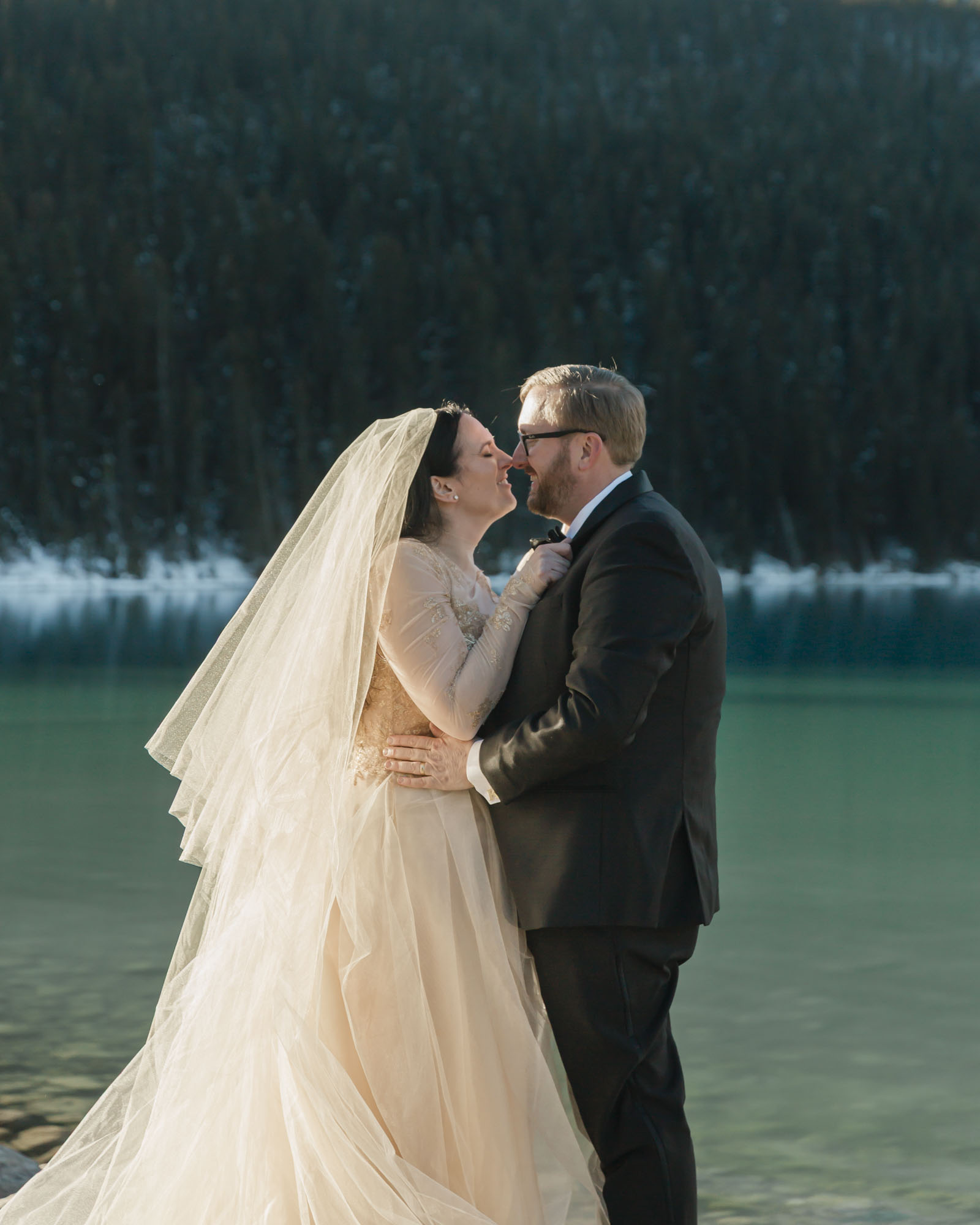 A couple's noses are touching romantically after their sunrise wedding in Banff National Park