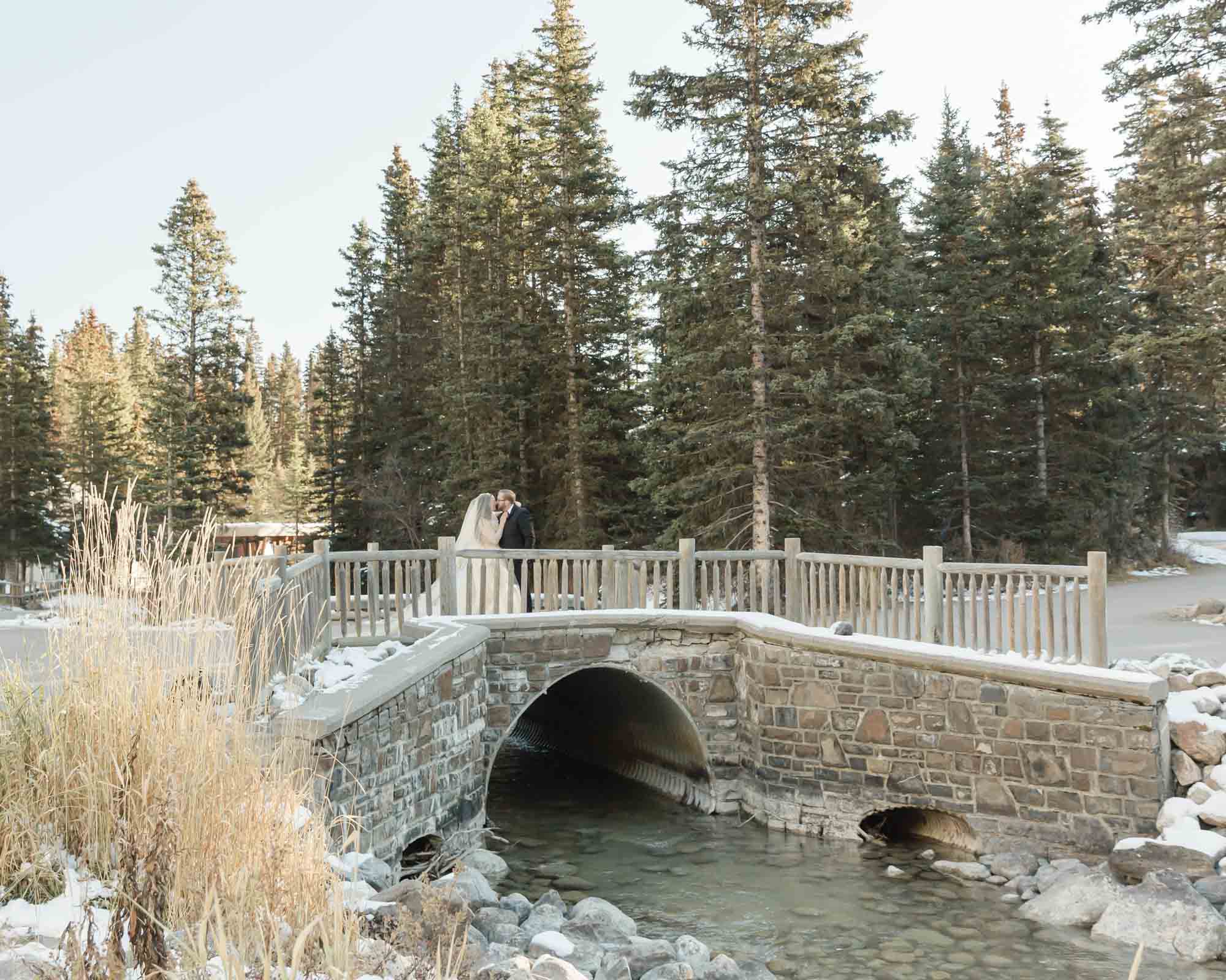 A couple walking along a bridge in Lake Louise after their elopement ceremony