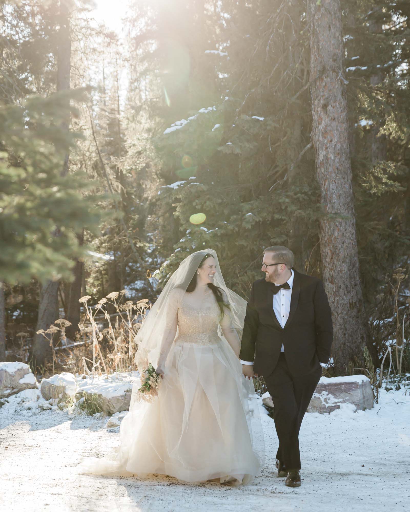 Wedding portraits in the forest in Banff National Park as they walk together hand in hand