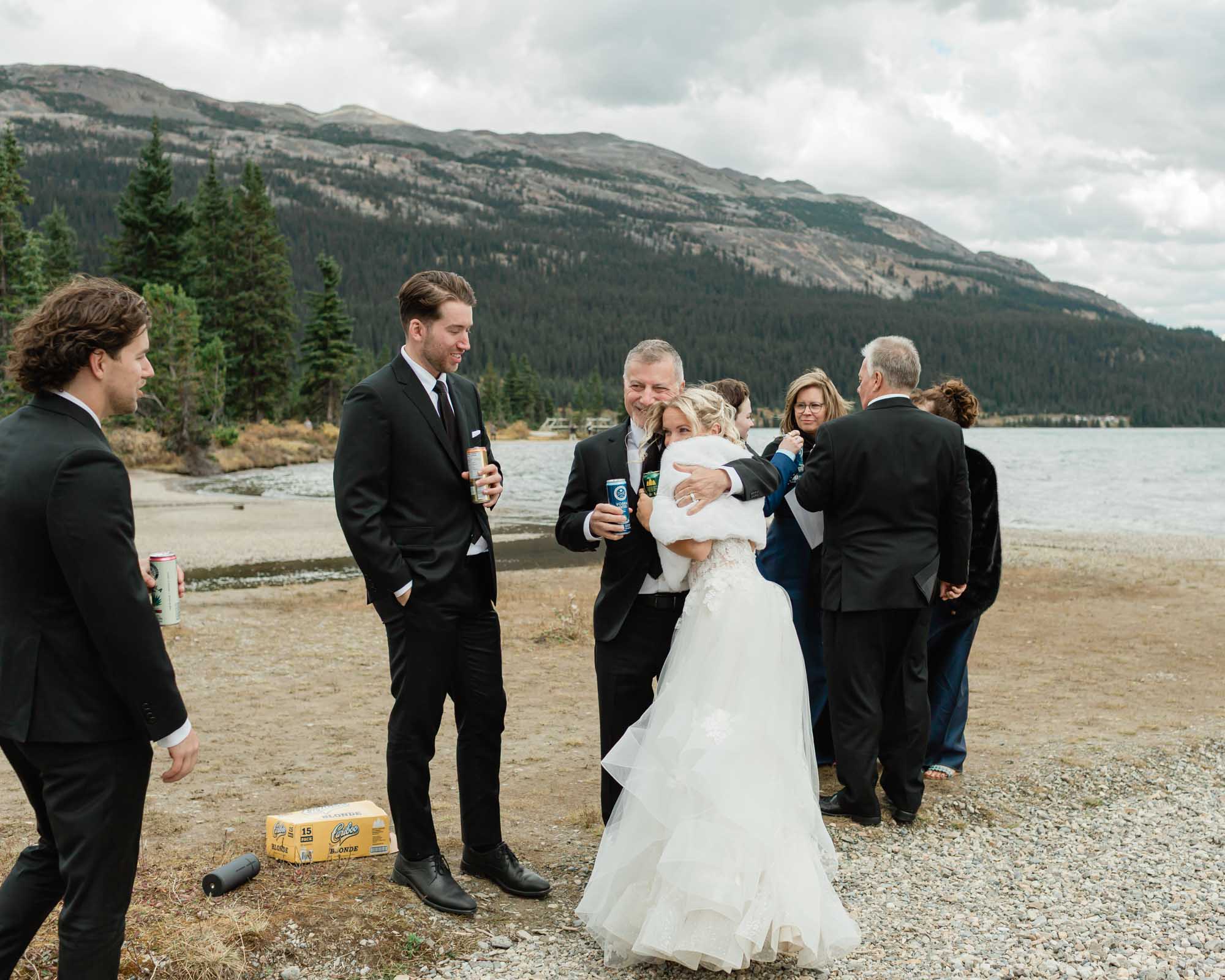 the bride and father in law embracing after her banff wedding 