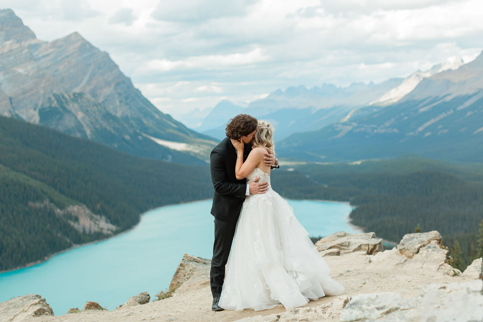 sarah and tyler embracing in front of peyto lake after their banff wedding