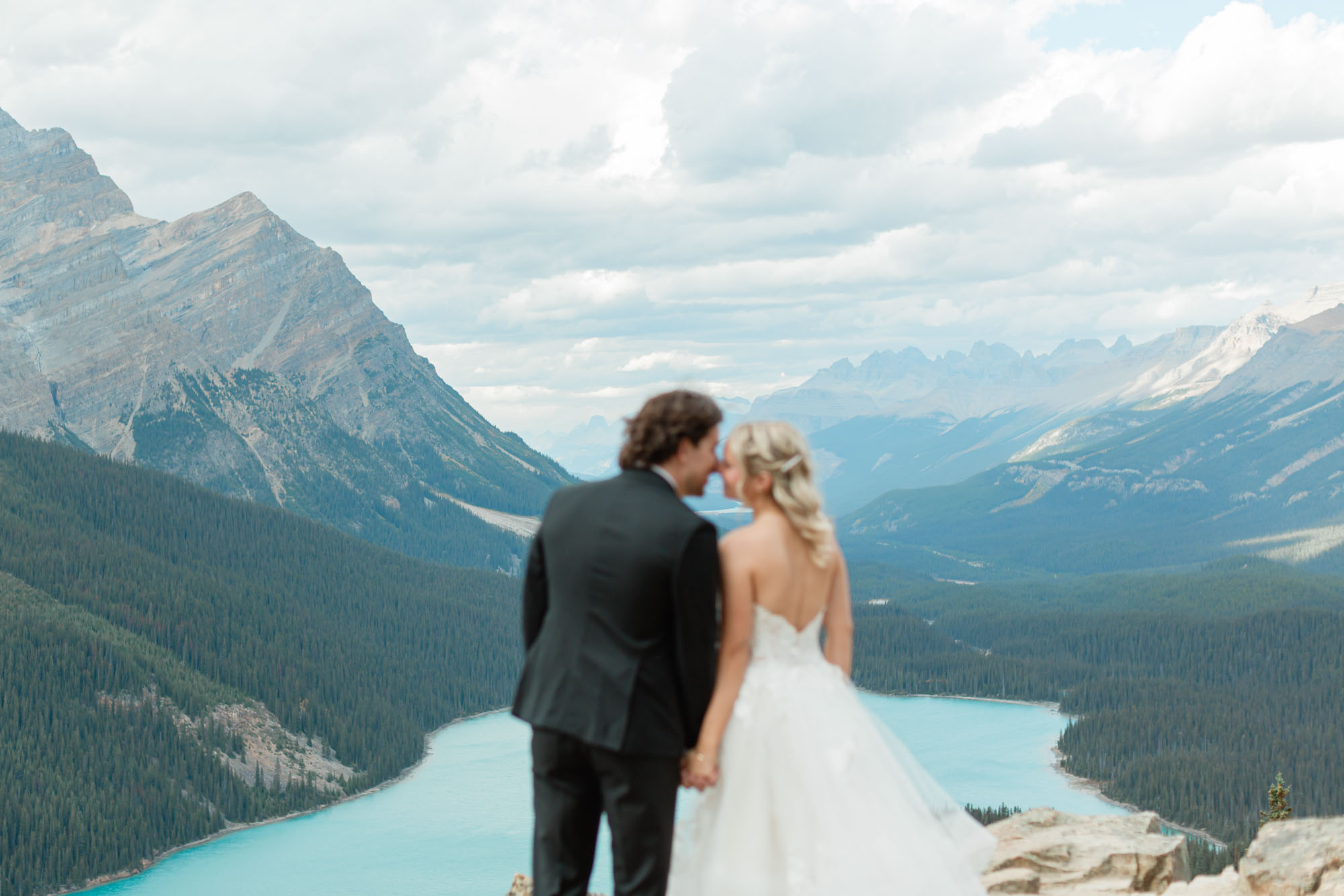 sarah and tyler holding hands in front of peyto lake after their banff wedding
